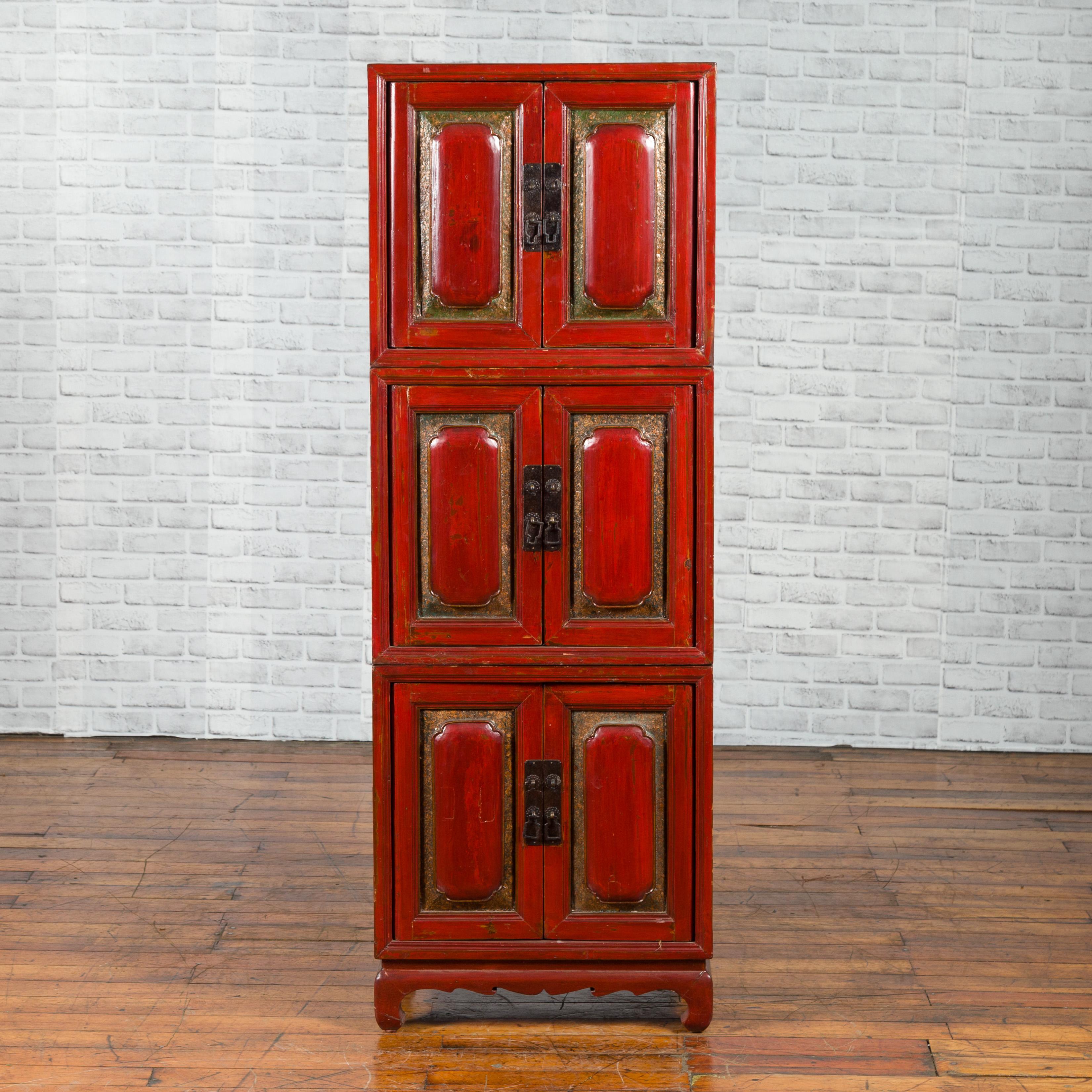 A Chinese red lacquered three-section stackable cabinet from the early 20th century, with polychrome lacquer. Created in China during the early years of the 20th century, this red lacquered cabinet is made of three independent sections stacked