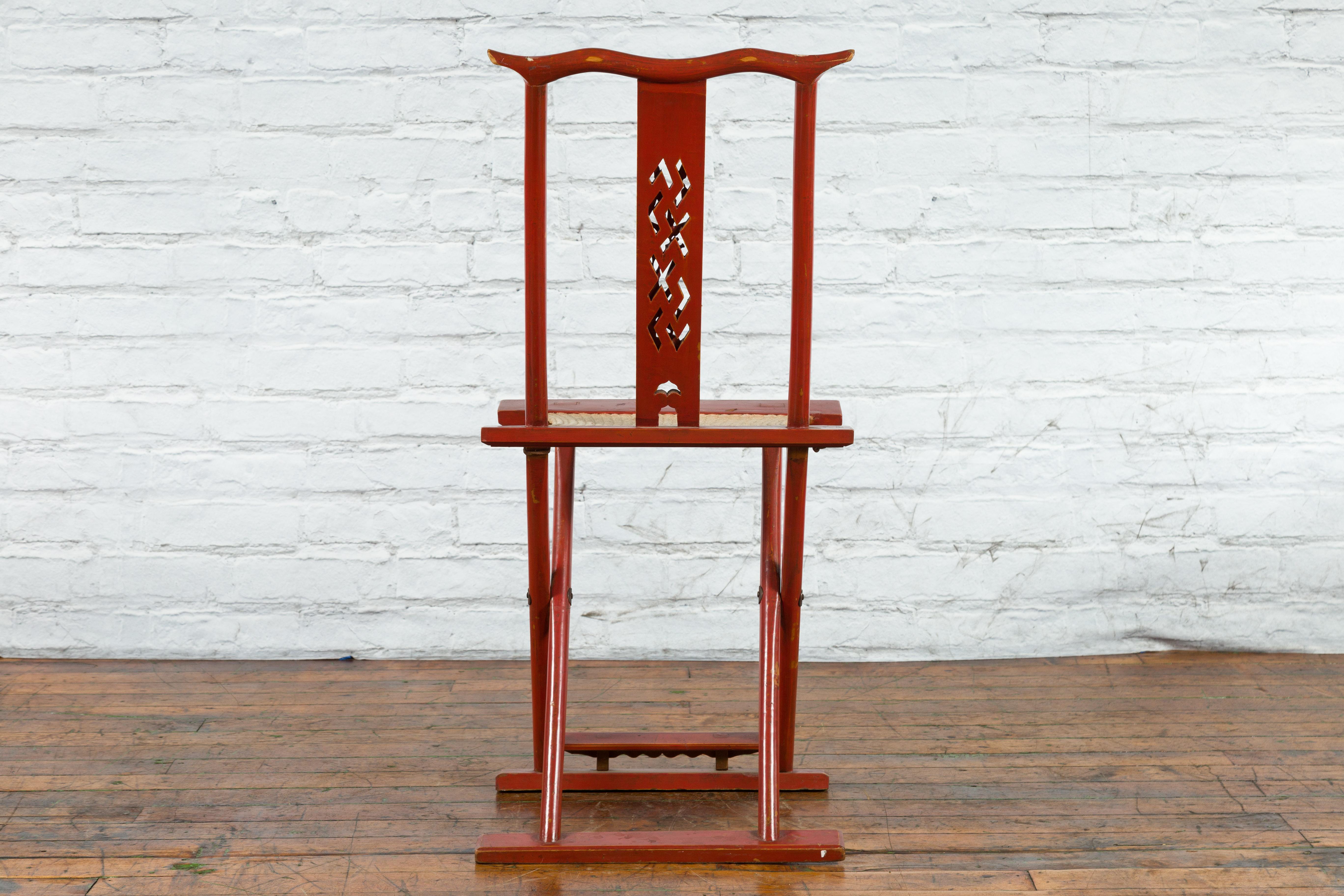 20ième siècle Chaise de voyage chinoise pliante en laque rouge du début du 20ème siècle avec assise tissée en vente