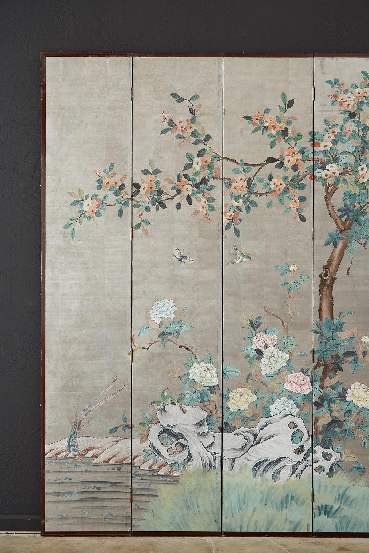 Monumental chinoiserie style eight panel screen made of wood panels covered with delicate silver leaf and hand-painted. Signed and sealed by artist Tian Jing on top right corner. Depicts a spring scene with flora and fauna dated with a cyclical year