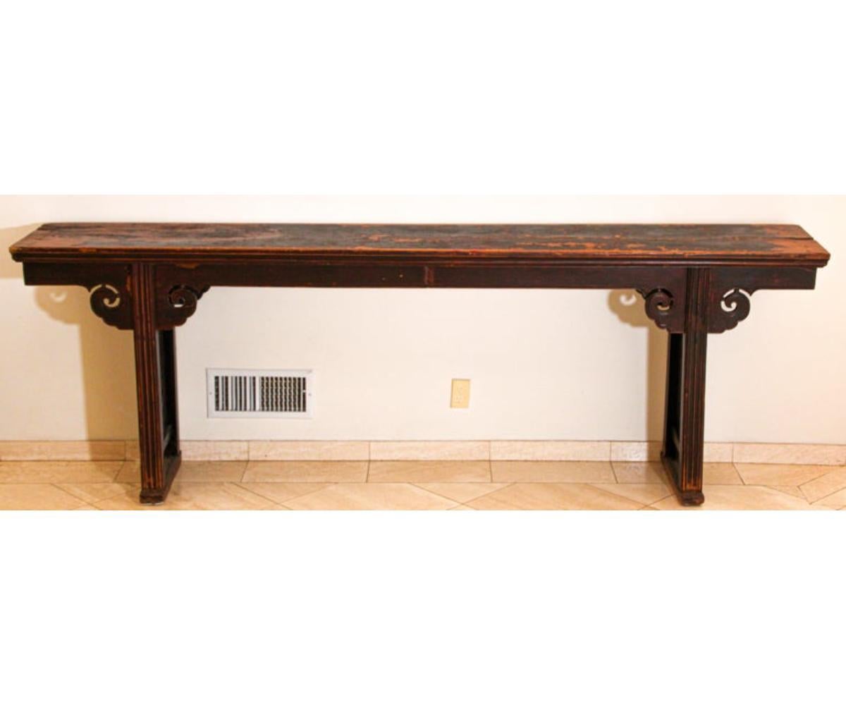 Chinese console table with hand carved spandrels on both side of the table.
A long elmwood altar or console table features side panels with carved, stylized ruyi motifs, a sacred fungus and with lingzhi carvings on corner spandrels of apron,