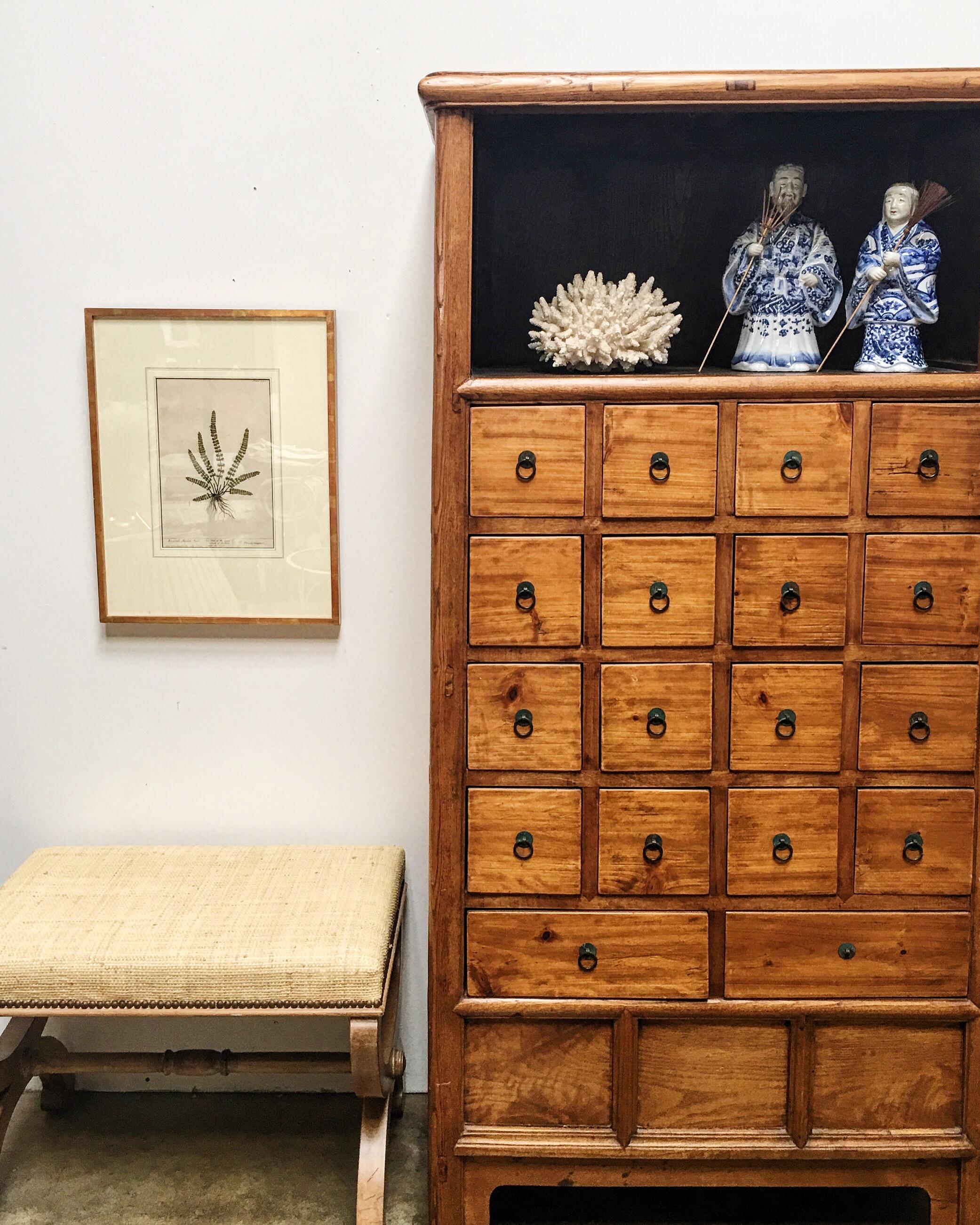 Impressive Chinese tapered apothecary herbal cabinet constructed of elm and made with mortise and tenon joinery. Featuring 18 drawers, each having a ring pull mounted on an antique Chinese coin ring. The top has an open storage shelf and the bottom