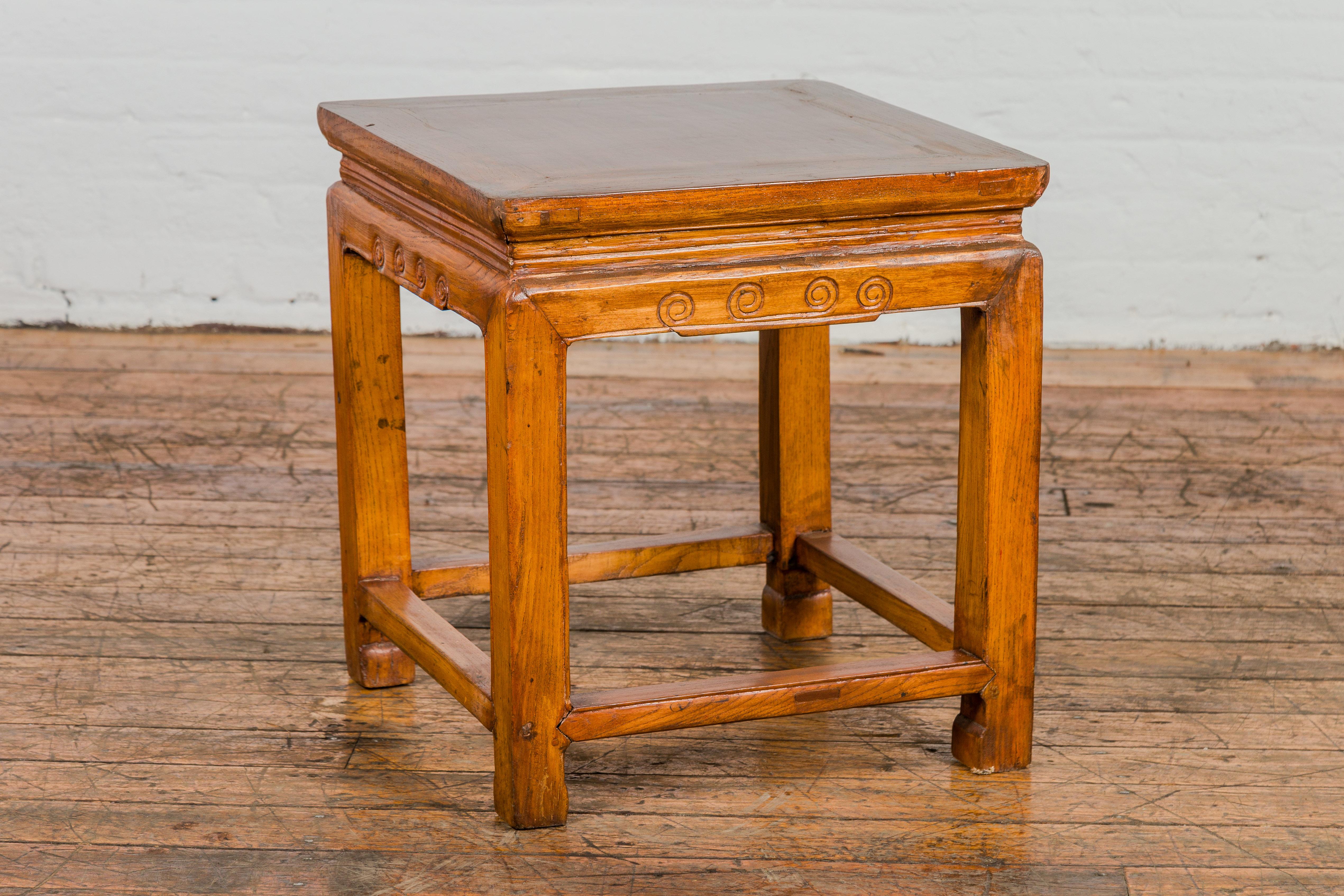 Enrich your home with the timeless elegance of this Chinese late Qing Dynasty elm side table, featuring horse hoof legs, side stretchers, and a carved apron.

The table's rectangular top, crafted from solid elmwood, exudes a sense of warmth and