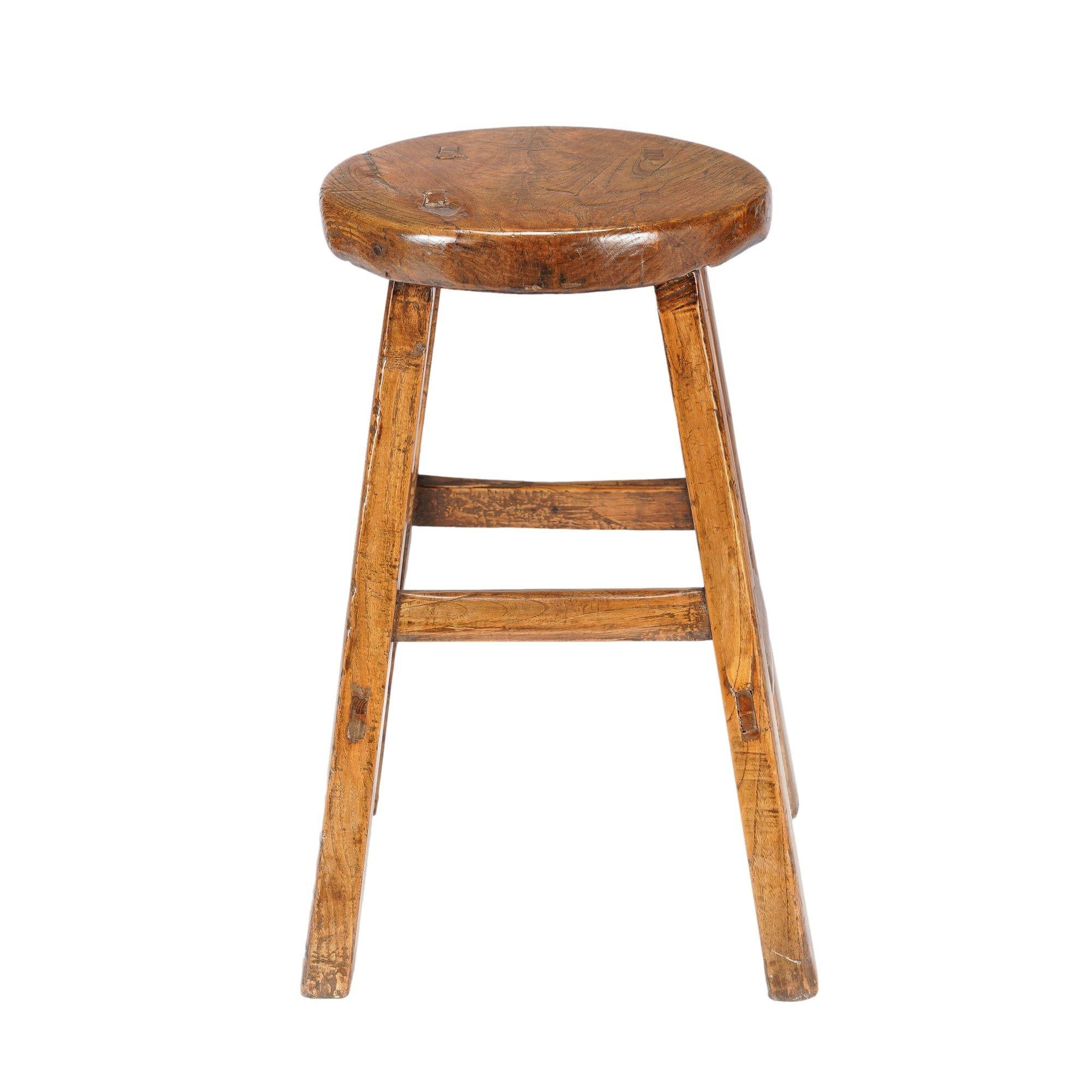 Tabouret provincial chinois en orme à plateau circulaire reposant sur quatre pieds carrés reliés par des entretoises à tenons et mortaises.
Chine, dynastie Qing, fin des années 1800.