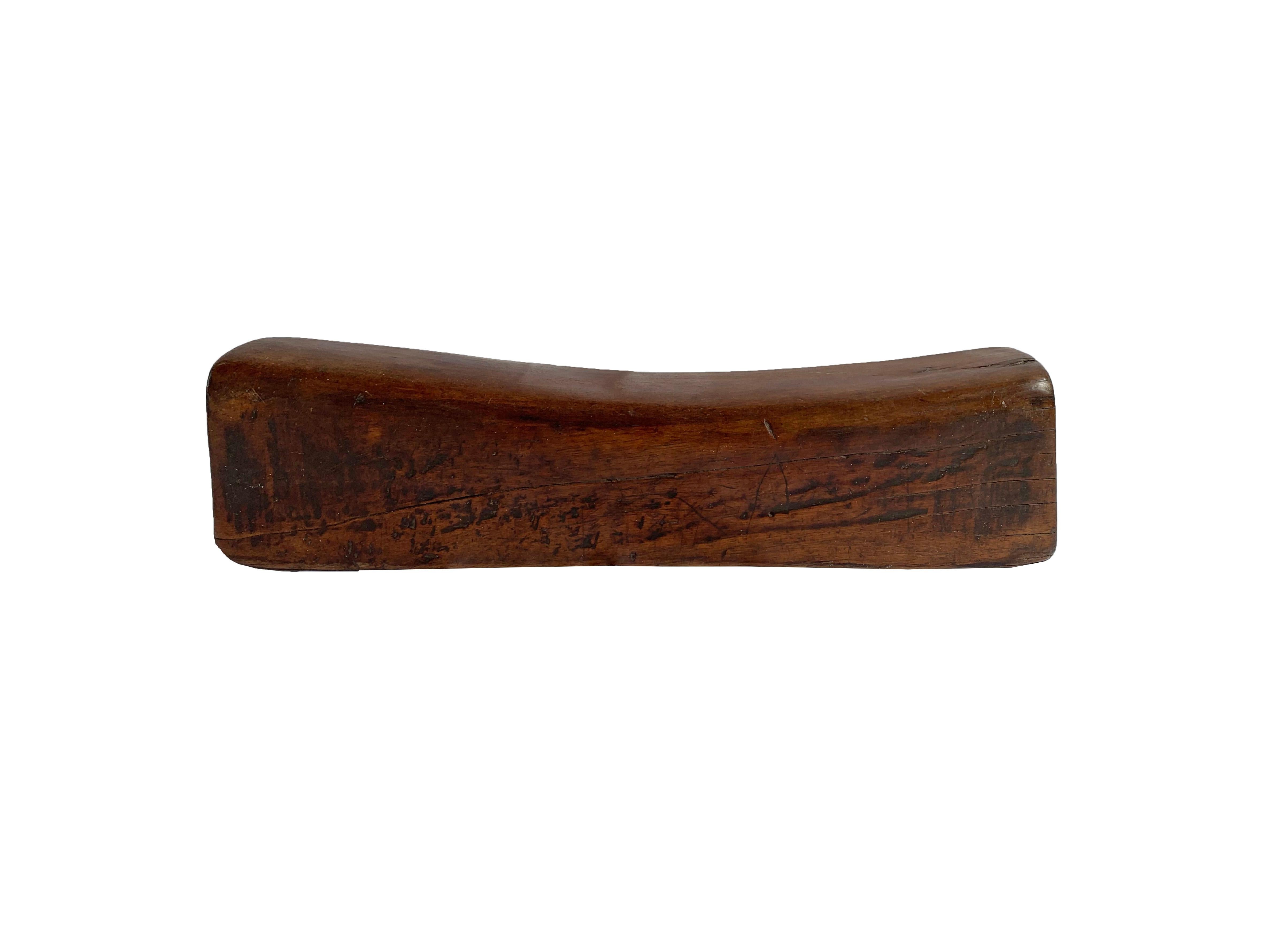 This antique Chinese headrest was crafted from elmwood and has a wonderfully smooth texture and elongated shape. It likely belonged to an upper-class individual to support their head. This piece has a lovely wood texture. 

Dimensions: Height 10cm