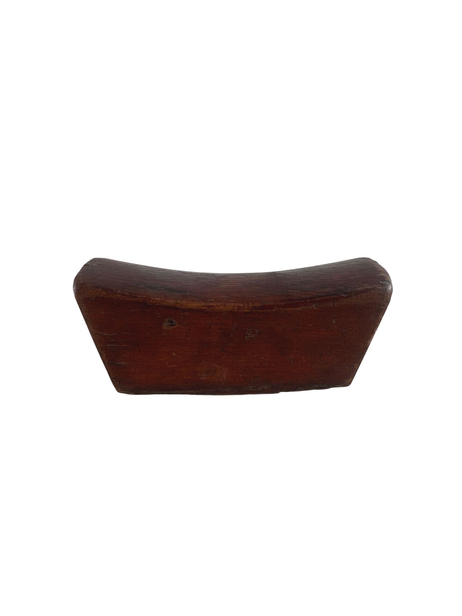 This antique Chinese headrest was crafted from elmwood and has a wonderfully smooth texture and elongated shape. It likely belonged to an upper-class individual to support their head. This piece has a lovely wood texture. 
 