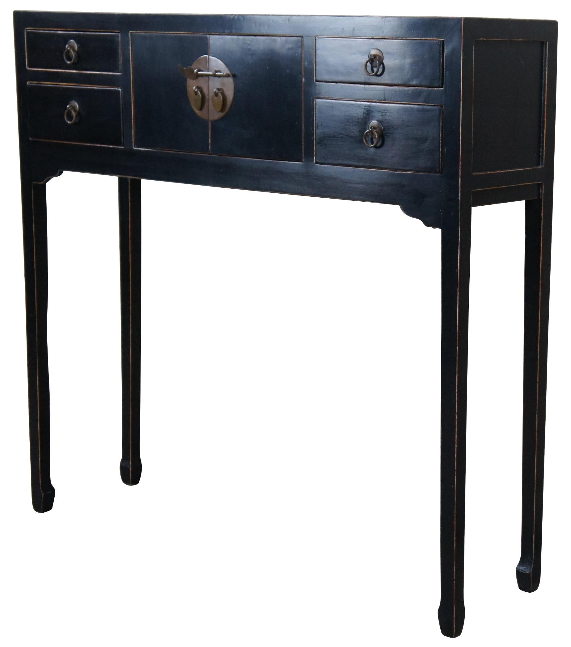 A lovely Chinese Ming style console. A nice complement to a hallway or behind a sofa. Black lacquered elmwood with a central cabinet flanked by four dovetailed drawers with brass hardware. Measure: 36