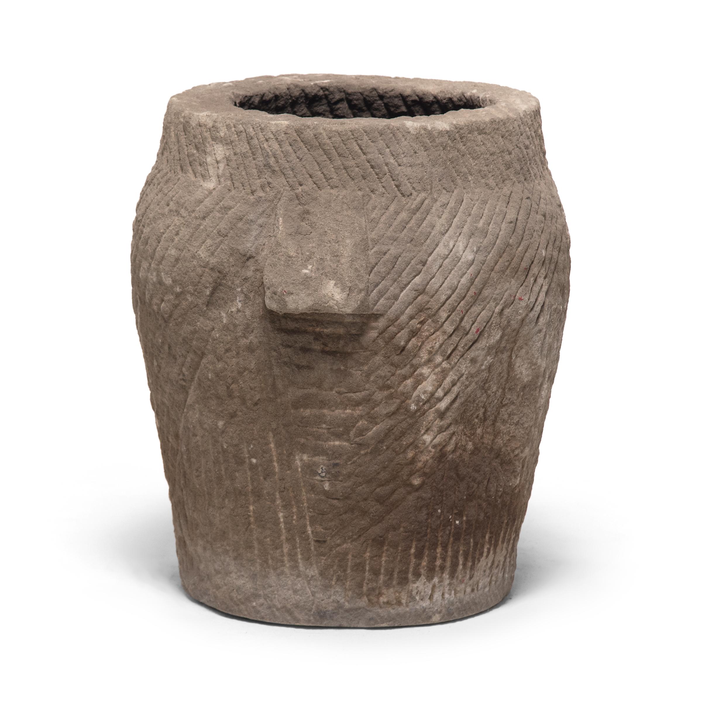 Essentially a utilitarian vessel, this mortar is textured with etched line work to facilitate the task of removing the outer husks from grains of rice. Yet it seems as if the Qing-dynasty artisan who carved the mortar from limestone became