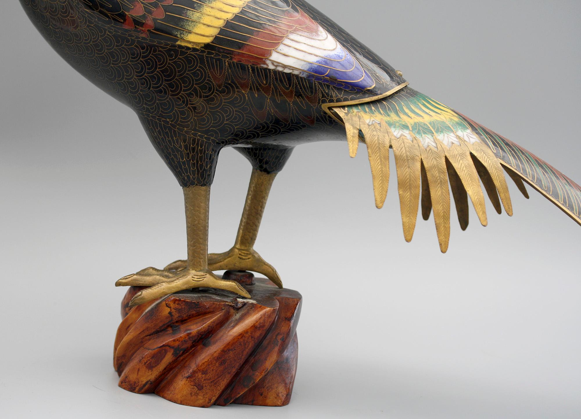 An exceptional and large Chinese vintage cloisonne enamel male pheasant mounted on a wooden stand dating from the first half of the 20th century. The pheasant stands on a shaped wooden block with brass claws, and a black enameled body with bright
