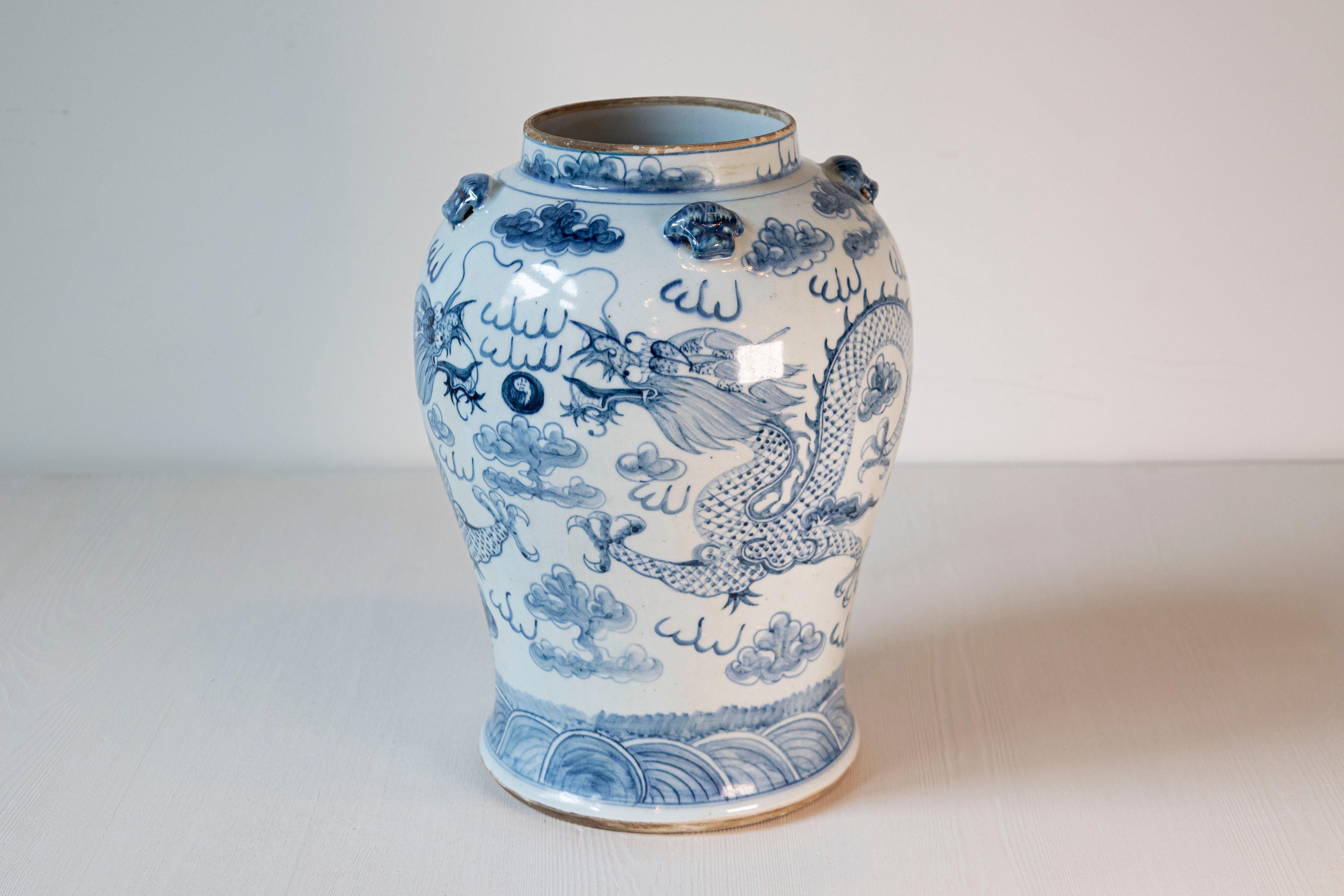 Vaso di porcellana cinese da esportazione in bianco e blu del XX secolo, con motivi di draghi. Creato in Cina durante il XX secolo, questo vaso di porcellana blu e bianca presenta un corpo ben curvo ornato da motivi di draghi circondati da nuvole,