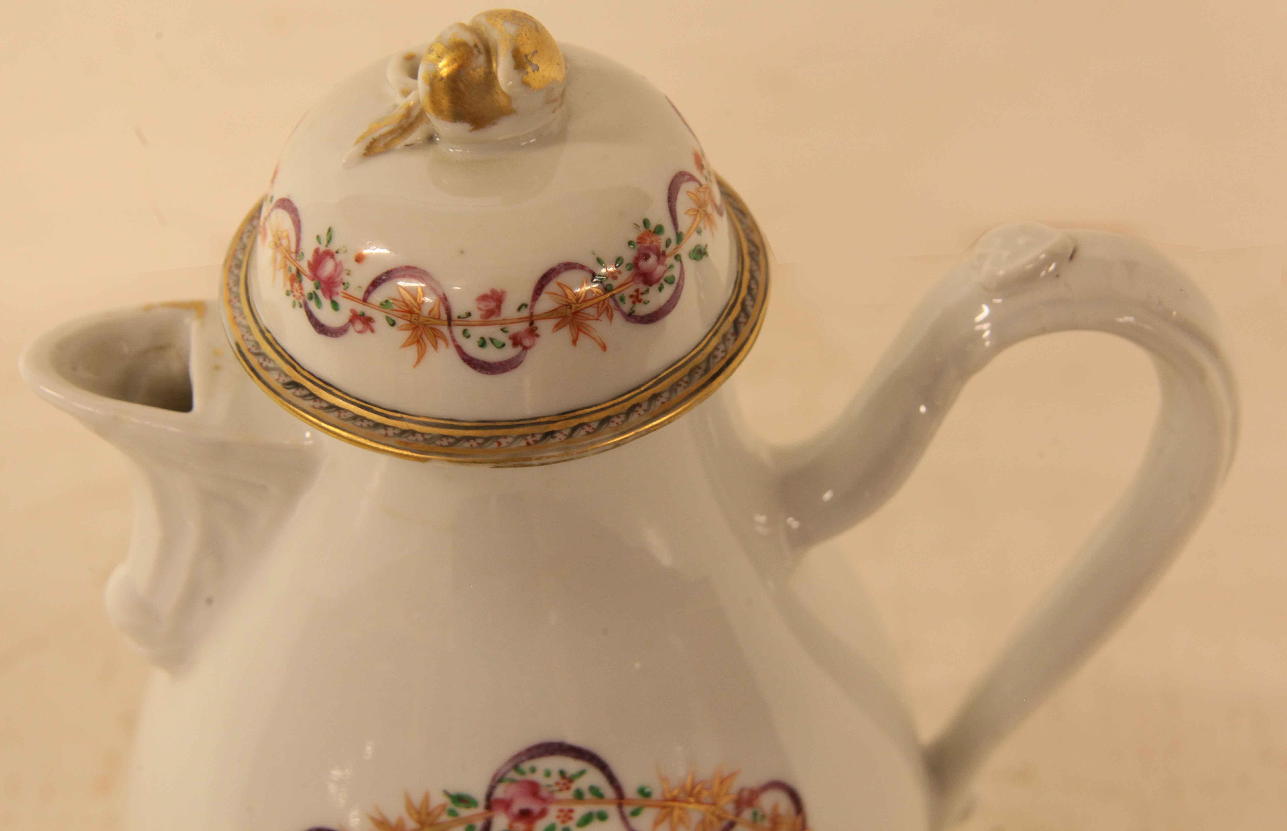 Chinese export armorial teapot, the lid with gilded acorn finial and the perimeter decorated with a floral pattern and a lavender thread line weaving in and out..  A larger version of this pattern repeats on both sides of the body . Centrally