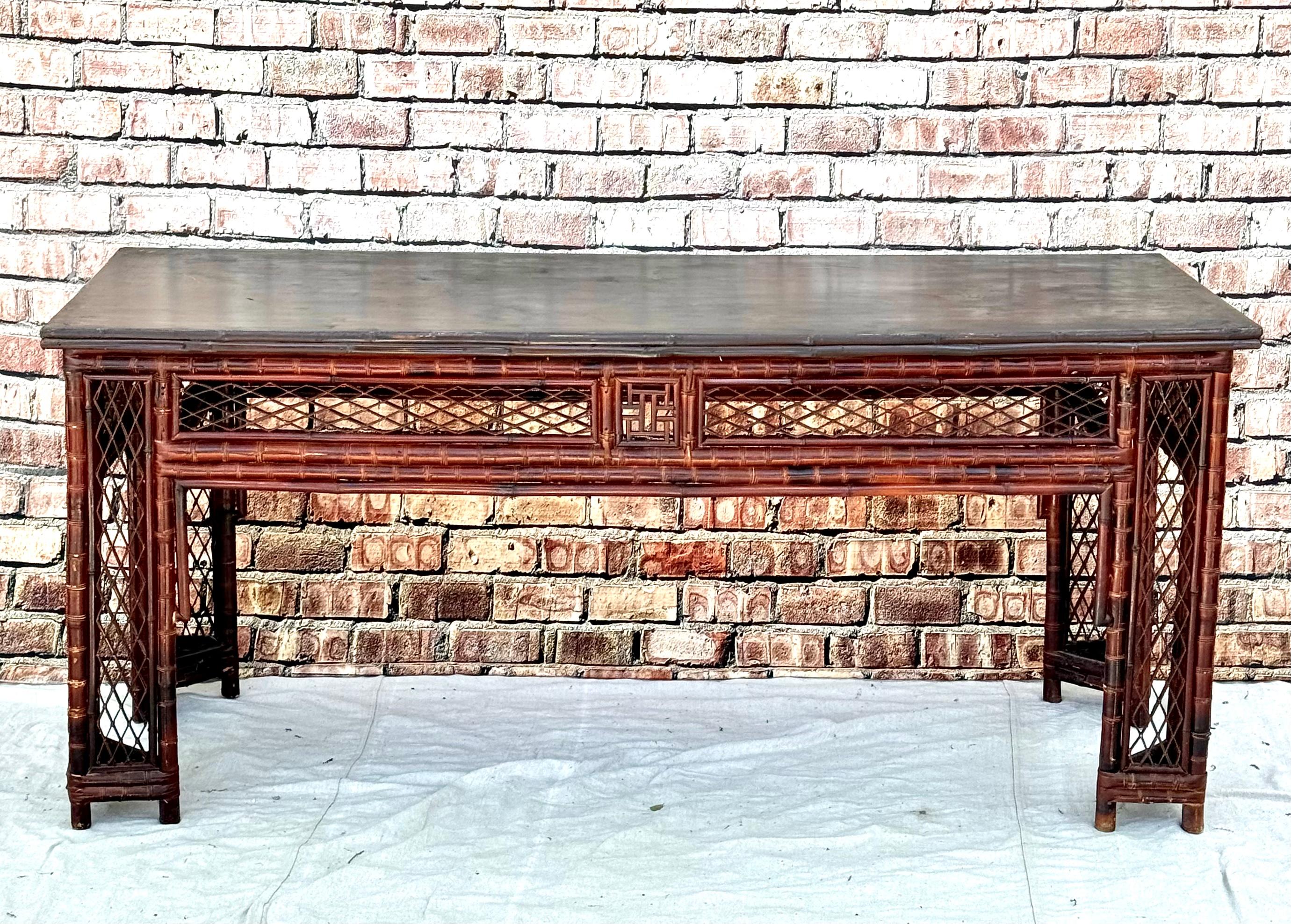 19th Century Chinese bamboo library table. Amazing Chinese export center or library table featuring intricate bamboo open fretwork on the aprons. The black wood table top is supported by bamboo fretwork legs. Beautifully crafted with Asian motif