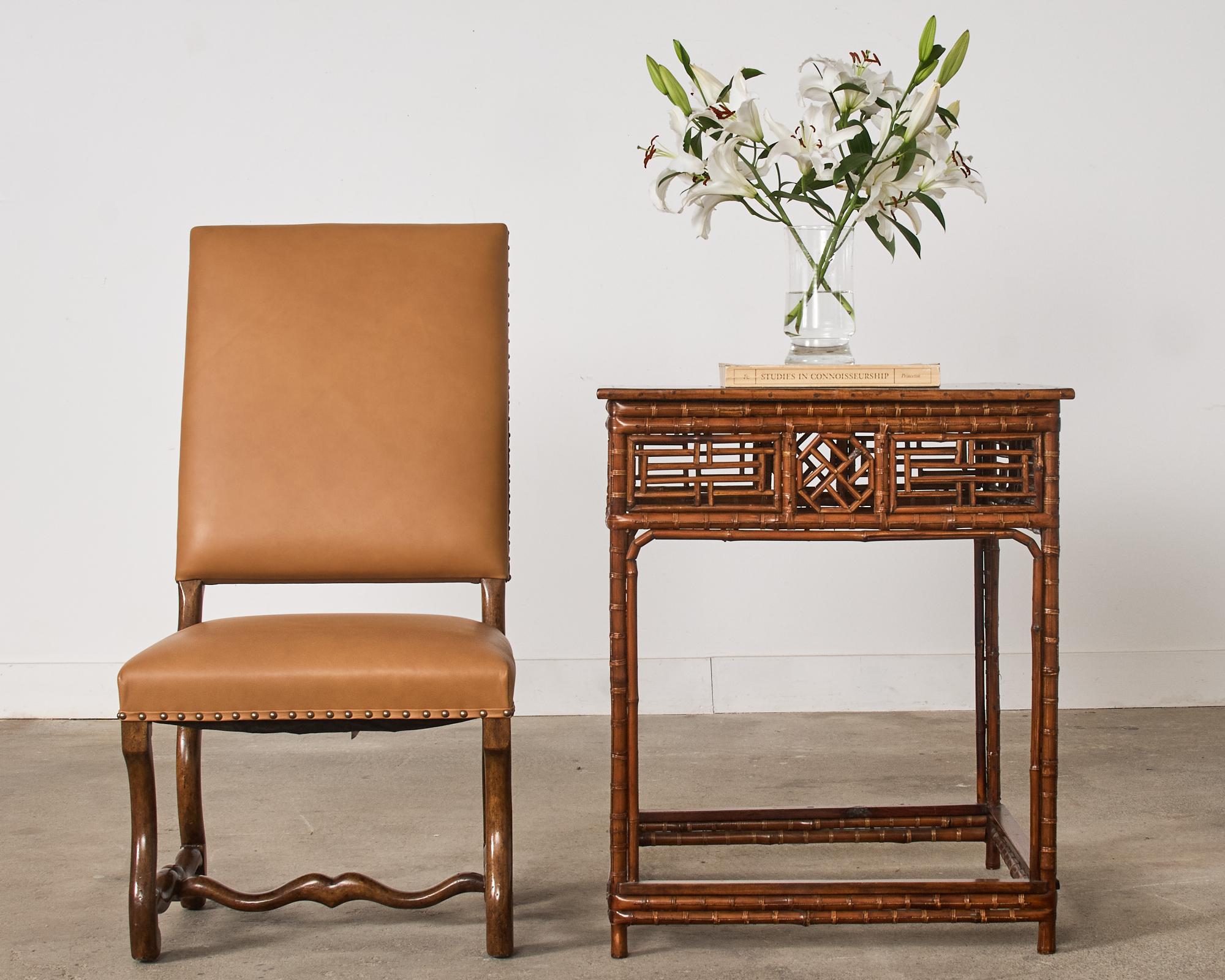 Amazing Chinese export center table featuring intricate bamboo open fretwork on the aprons. The top of the square table has a black lacquered piece of wood supported by round bamboo legs that are conjoined on the bottom with box stretchers.