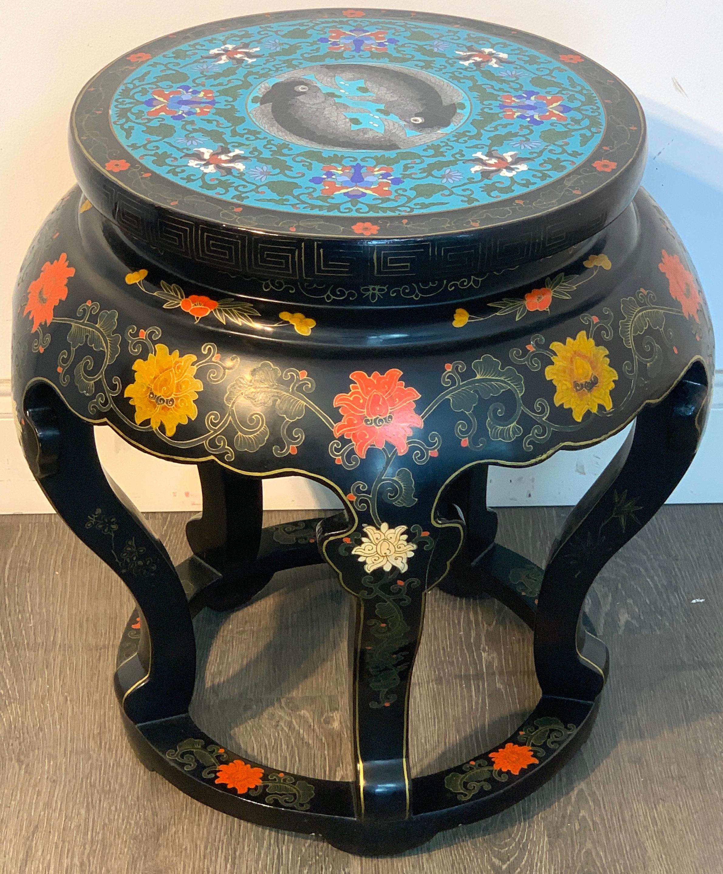 Chinese export black lacquer cloisonné koi motif table, with a 15-inch diameter koi motif cloisonné plaque, raised on floral incised polychromed lacquer base.
The table has a 19