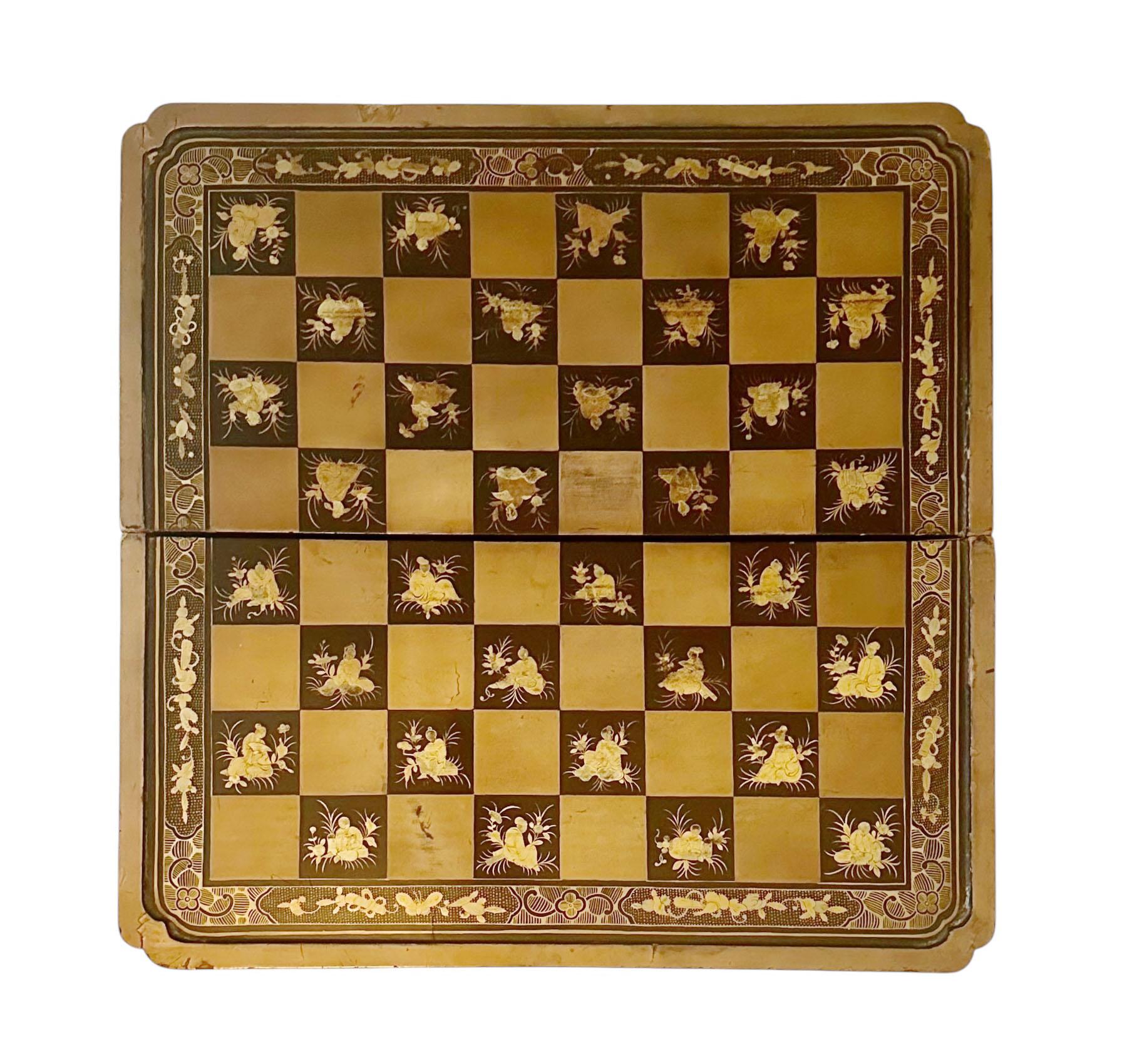 Caja de juego plegable de exportación china, elegante y con intrincados detalles, fabricada en madera lacada con decoración dorada, de principios del siglo XIX. El exterior presenta escenas cortesanas bellamente representadas en oro, rodeadas de