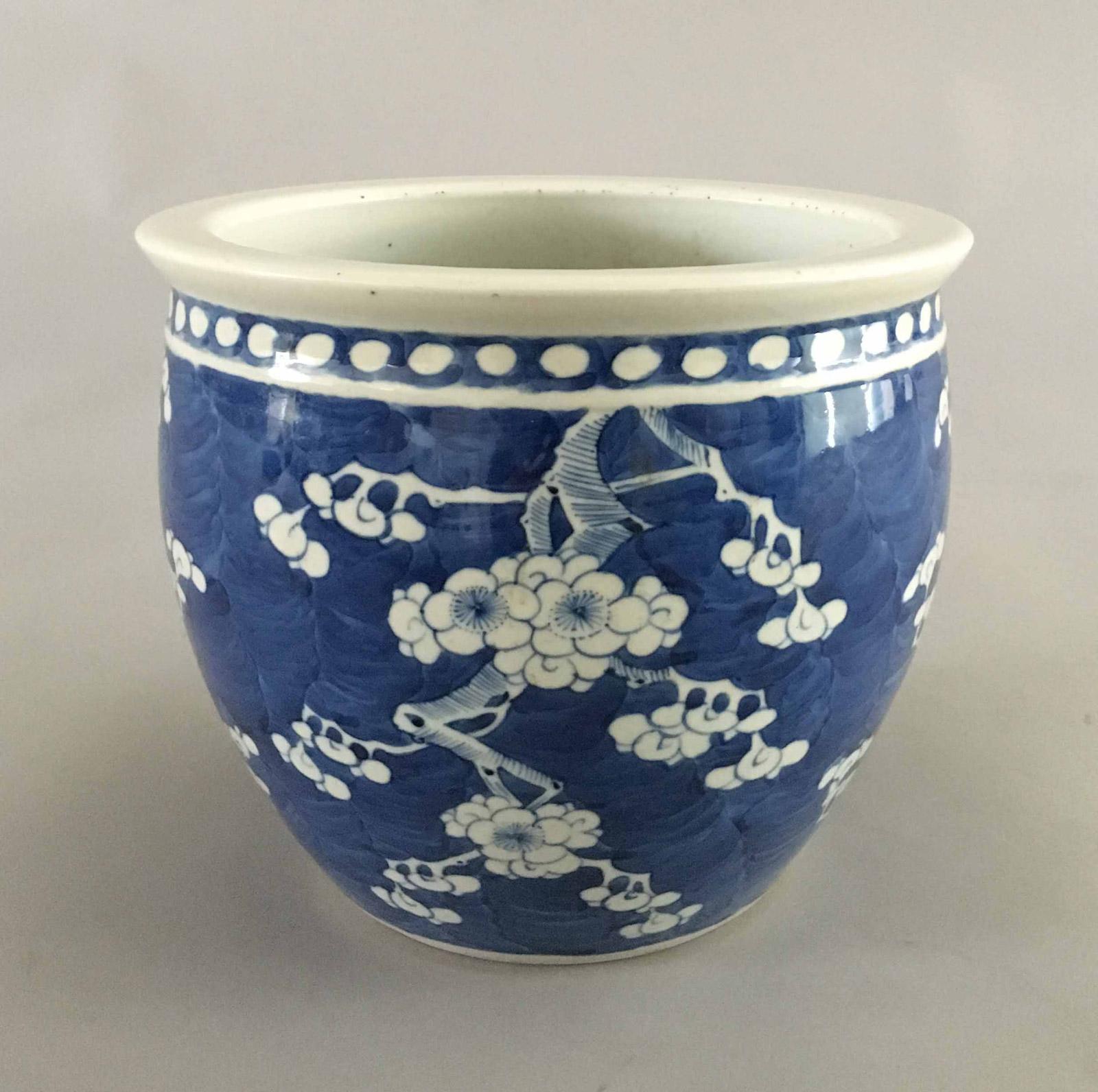 Chinese Export porcelain blue and white jardiniere decorated with prunus branches and blossoms, against a brilliant underglaze cobalt blue background, with a four-character mark to the base.