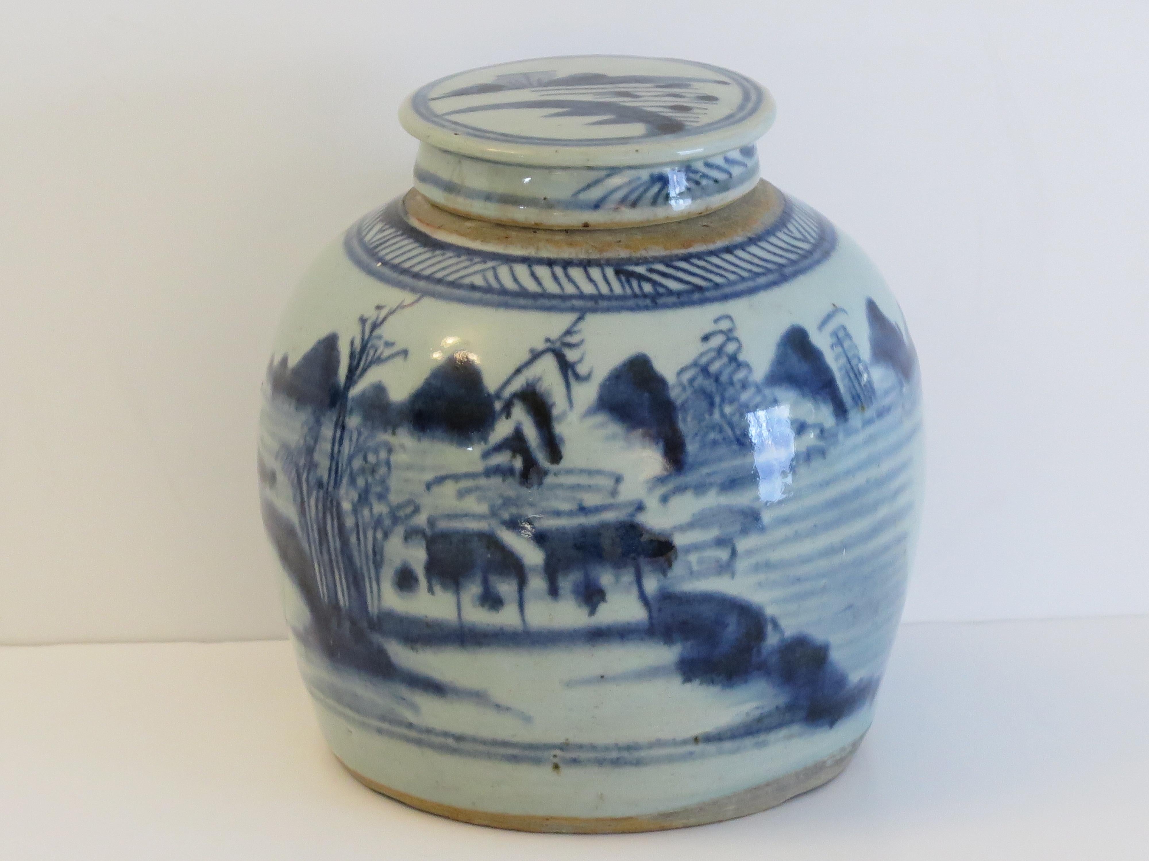 This is a heavy Chinese Export porcelain jar complete with lid, hand painted with a blue and white lakeside scene and dating to the late 18th century, Qing dynasty.

This is a well potted piece with a very decorative bulbous shape and a glassy glaze