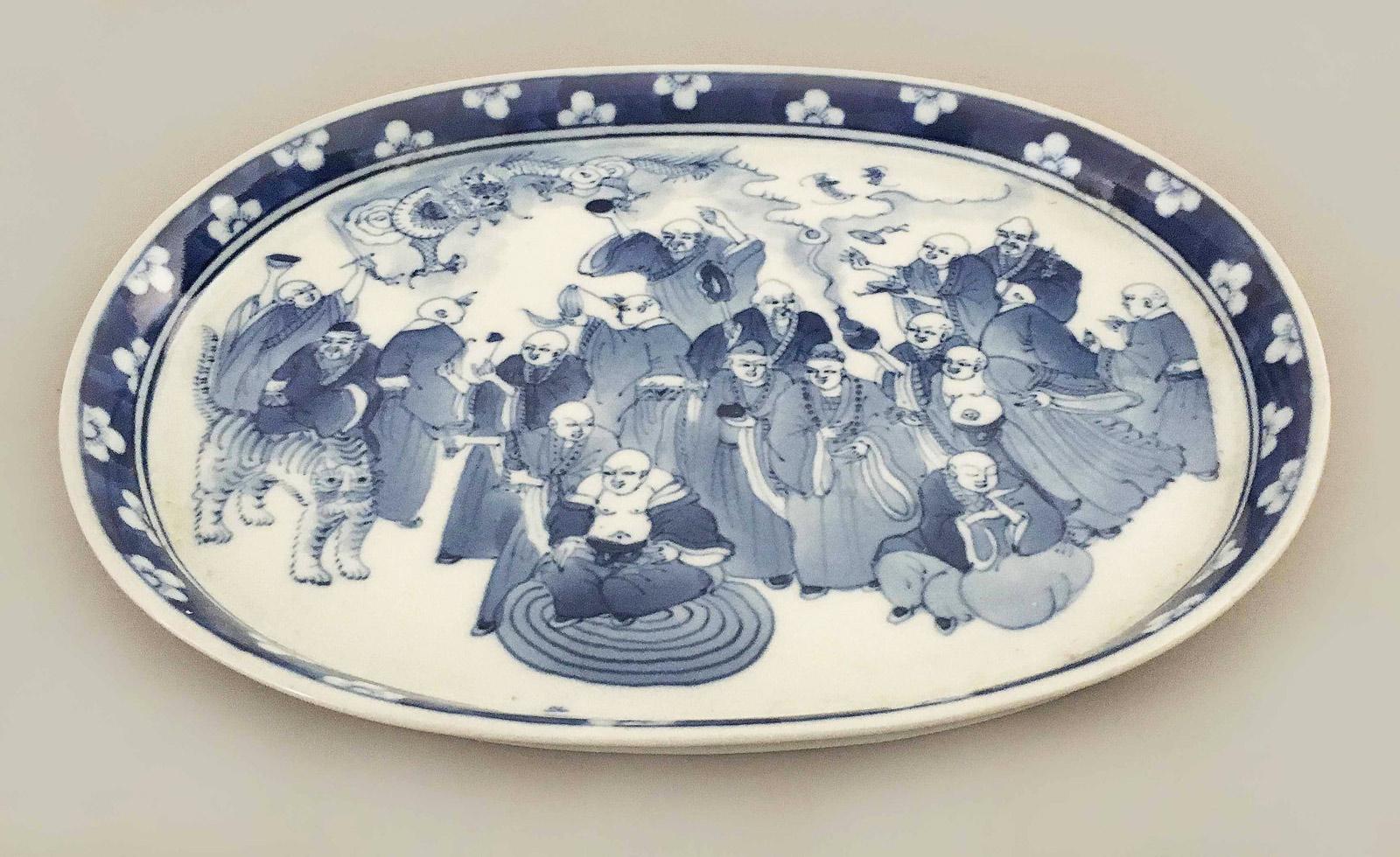 Chinese Export porcelain blue and white small oval tray decorated with immortals celebrating, dragons flying, an immortal riding a tiger and incense emanating from an urn. The border is a hawthorn pattern of prunus blossoms on cracked ice. Utterly