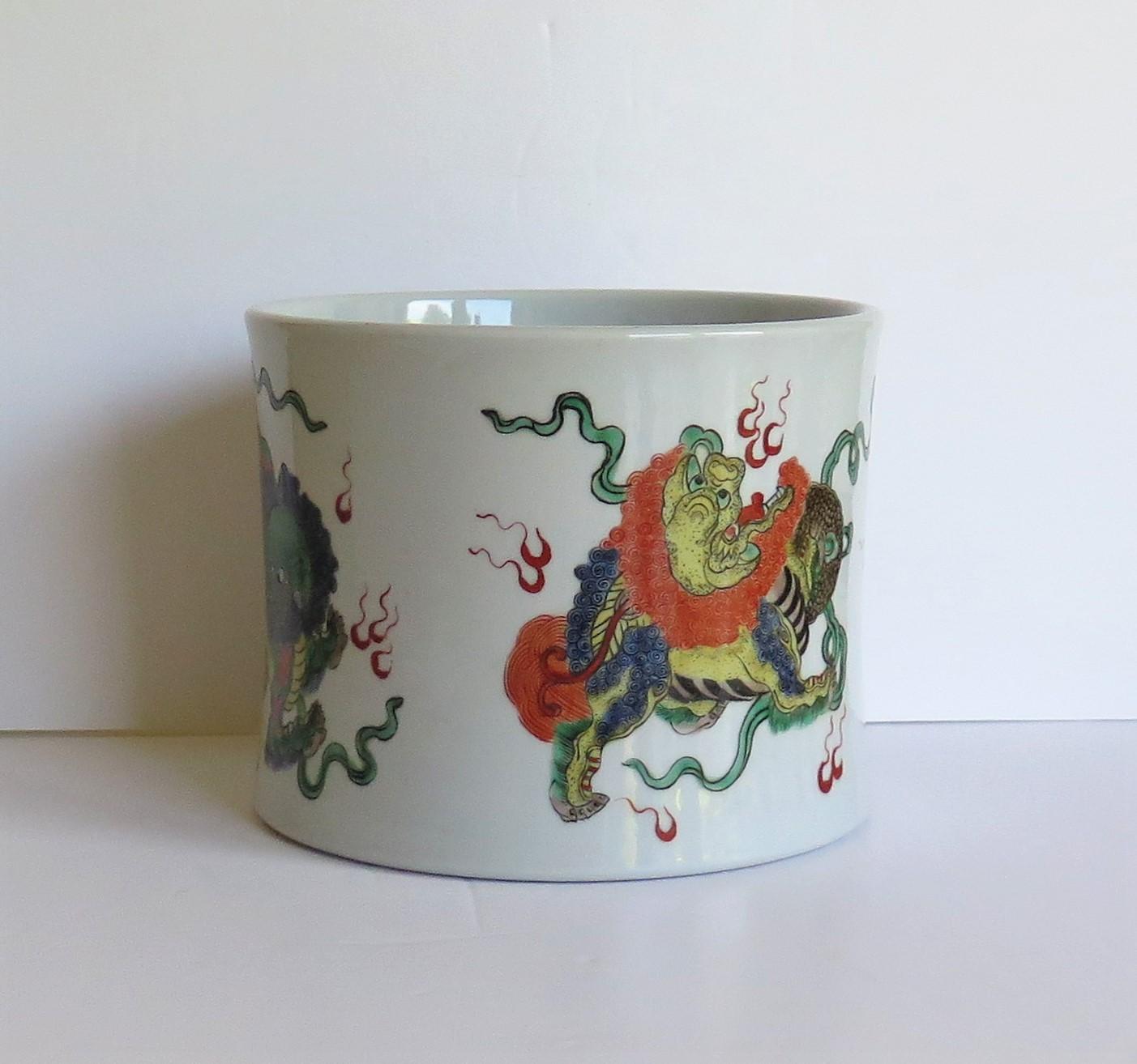 This is a very good Chinese export porcelain brush pot or Bitong hand painted in polychrome enamels with an apocryphal six figure Kangxi mark but dating to the mid-20th century.

This piece is very well potted and has a very attractive squat shape