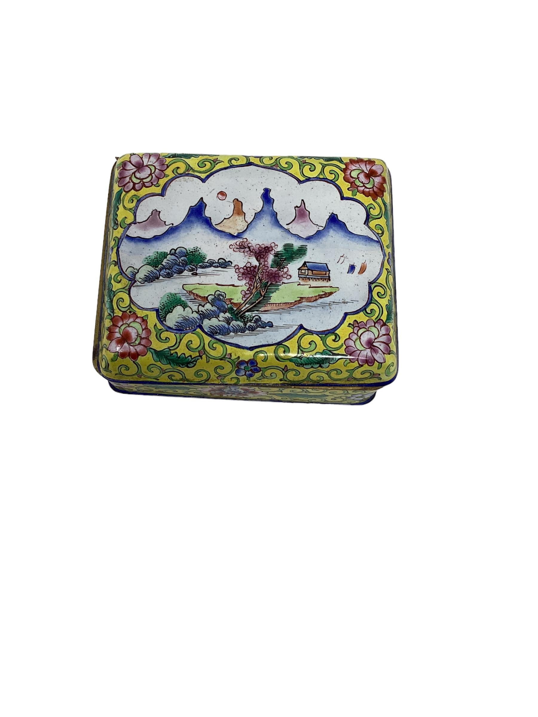 Lovely Chinese export cloisonné box made of brass and enameled with a beautiful mountain scene decoration in vibrant yellow color resting on ball feet. This chinoiserie box is marked china and dates from 1900-1920. This decorative box was most