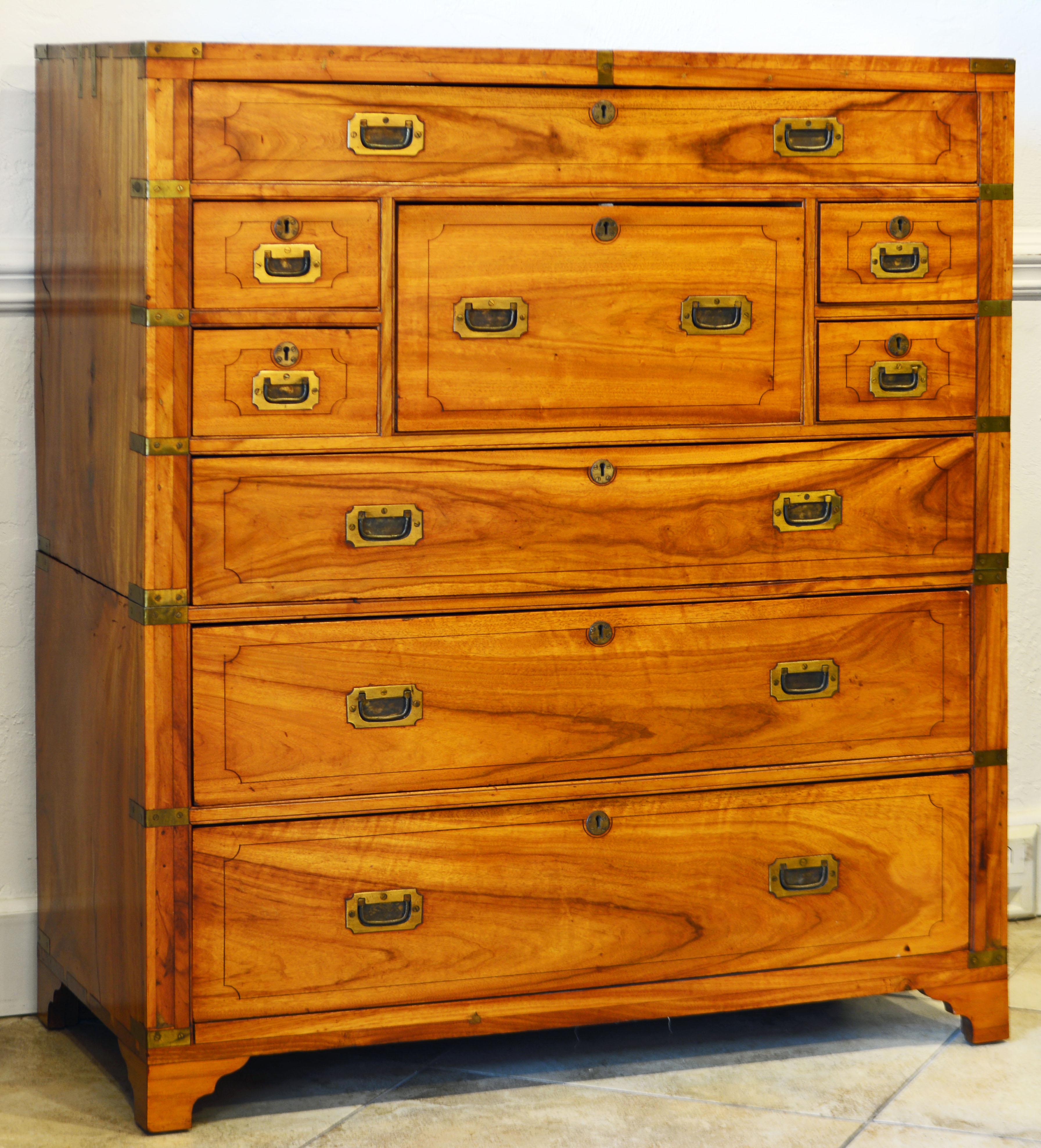 This superior campaign chest and secretaire displays the honey colored camphor wood in all its glory. It consists of an upper and a lower part with two long drawers. The upper part has two long drawers and four smaller drawers centering a pull out