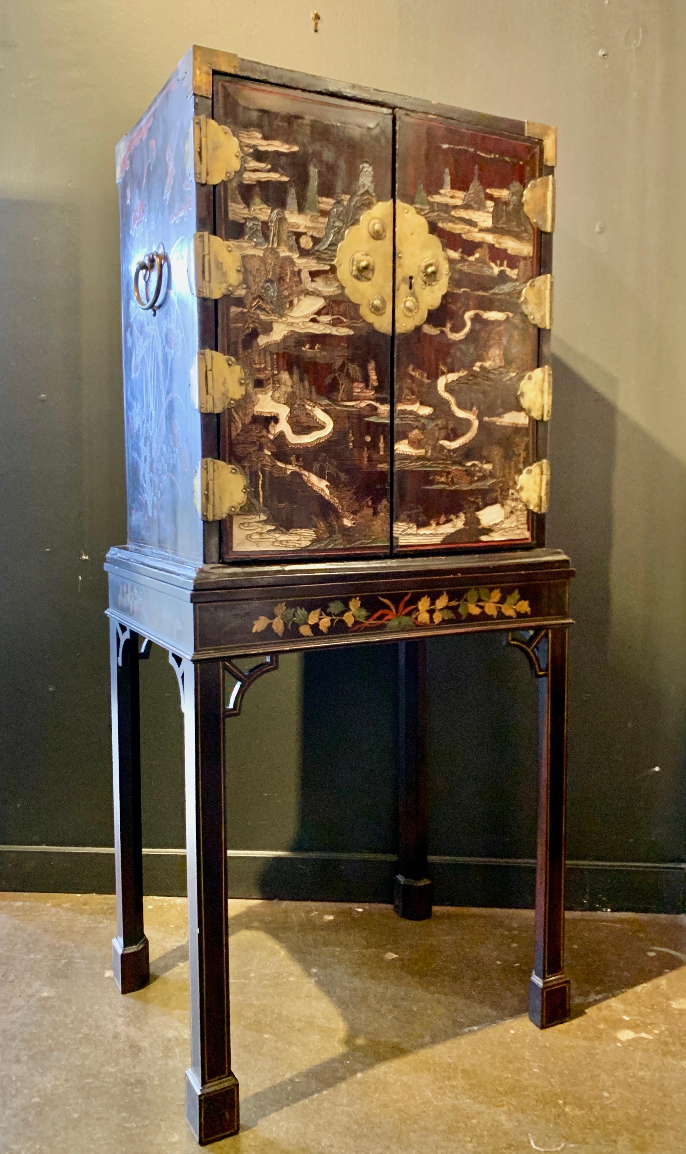 A delightful Chinese coromandel brown lacquer cabinet on stand, made for the export market, early to mid-19th century, China, presented on an early 20th century custom fitted stand. 

The gem of a cabinet is fitted with doors and drawers, and