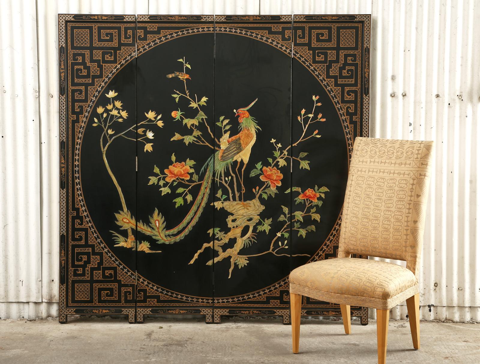 Dramatic Chinese export Coromandel screen featuring a large phoenix crafted from painted mother of pearl. The four-panel screen has a black lacquer ground with parcel gilt geometric borders making a round window frame. The center is decorated with