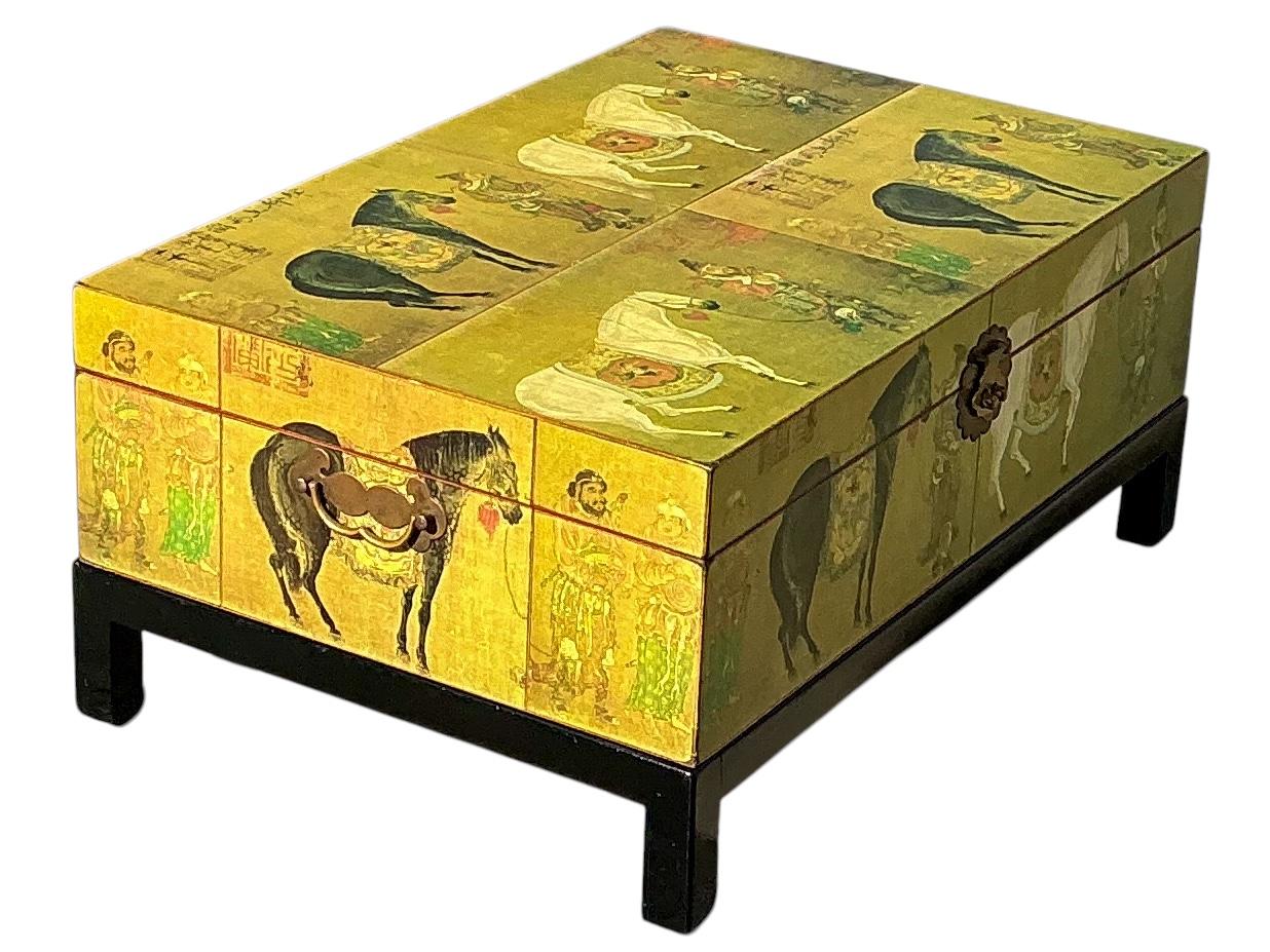 This is a Chinese Export style dowry trunk on ebonized base. It is beautifully painted and depicts a Chinese ceremonial horse parade. The brass hardware is intentionally weathered. It opens to nice storage and would make a great coffee table.
