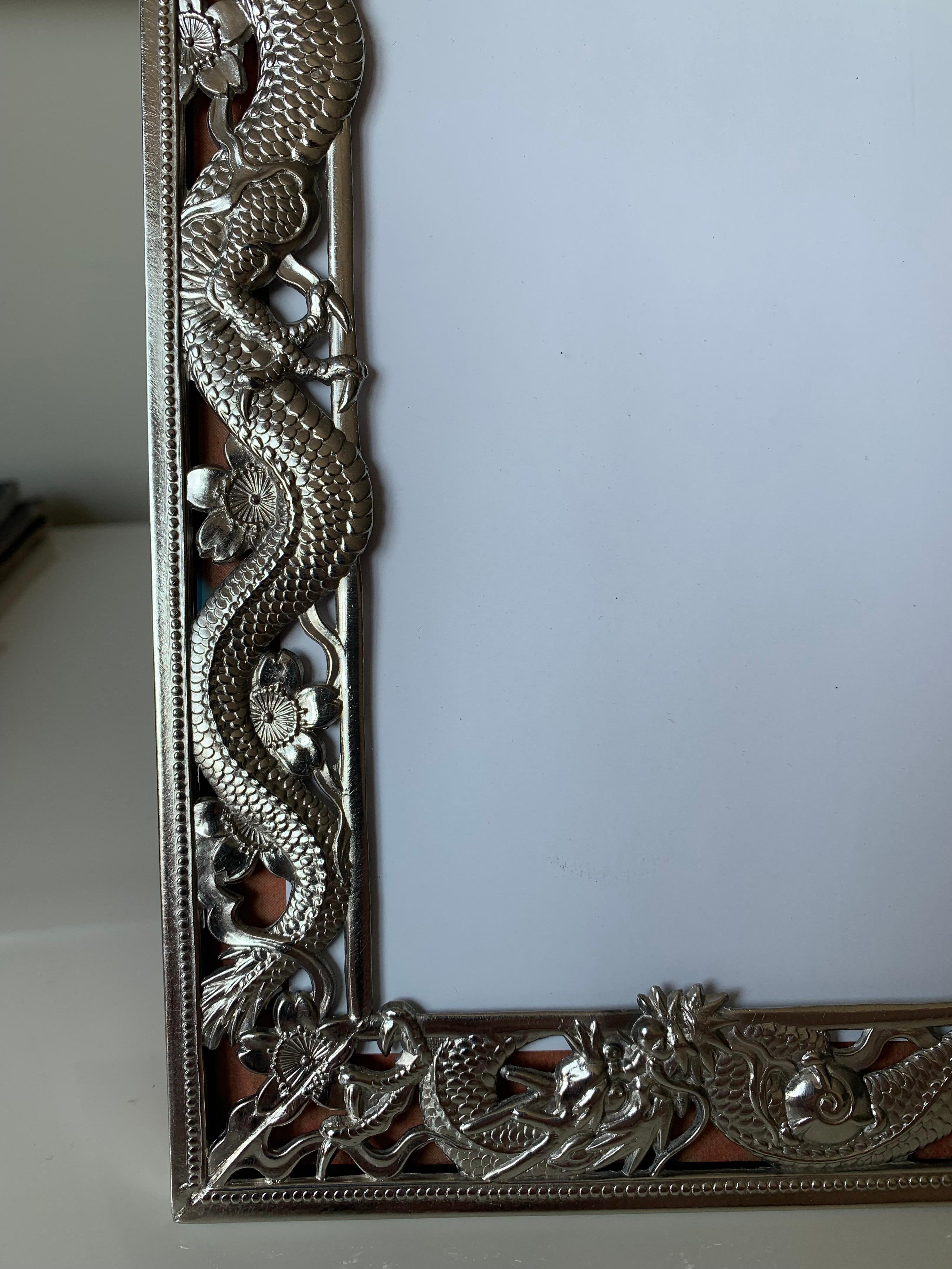 Chinese export dragon motif silver plate picture frame. Newly replaced. New low glare clear glass. Original burgundy leather easel back. Opening is 9.5” tall x 7.5” wide.