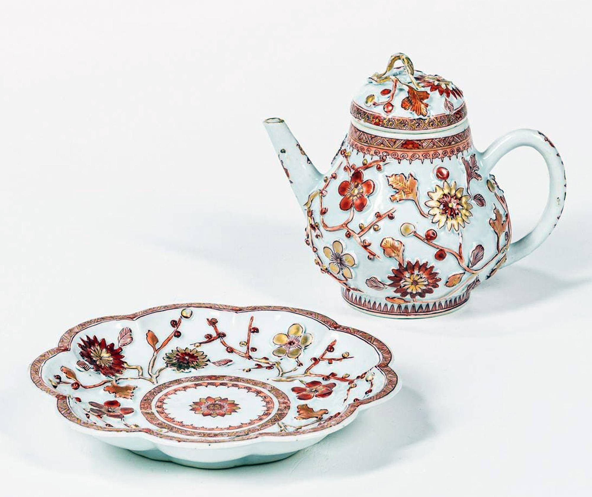 Chinese Export early 18th century Rouge de Fer porcelain teapot, cover & stand,
Kangxi,

The pear-shaped Chinese Export porcelain teapot with molded raised flower heads and stems in a rouge de fer & gilt with its circular stand. The raised