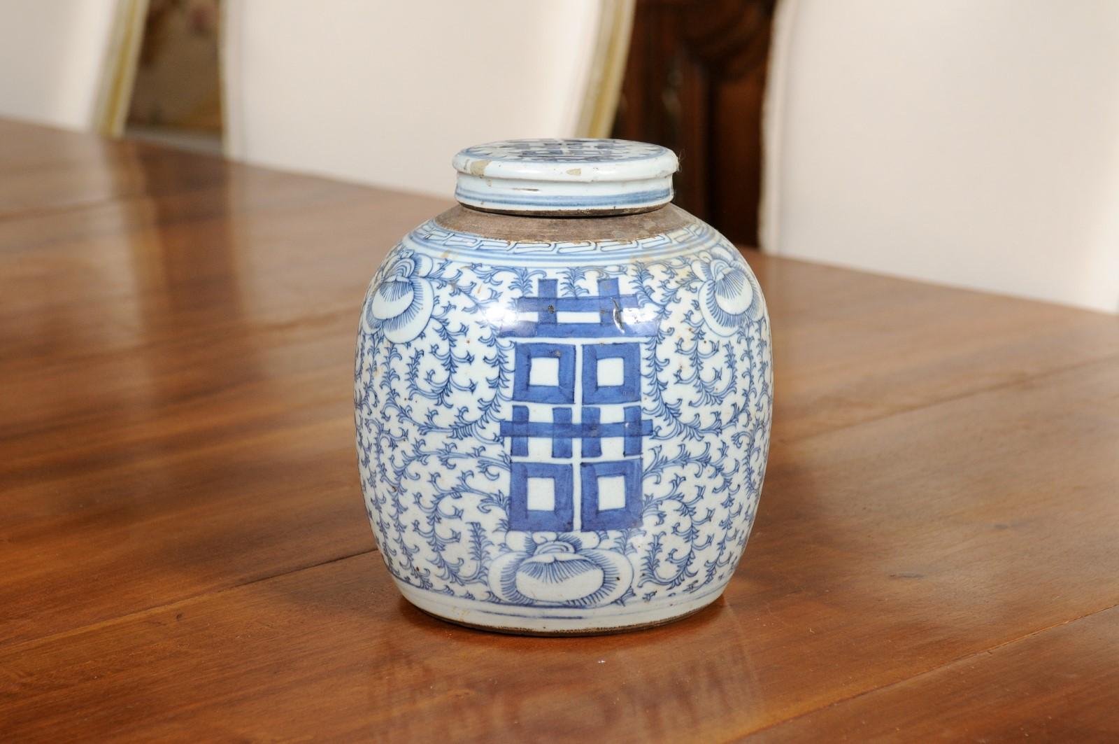 A Chinese Export blue and white Double Happiness lidded jar from the early 20th century, with scrolling foliage. Created in China during the early years of the 20th century, this porcelain jar features the Double Happiness motif standing out