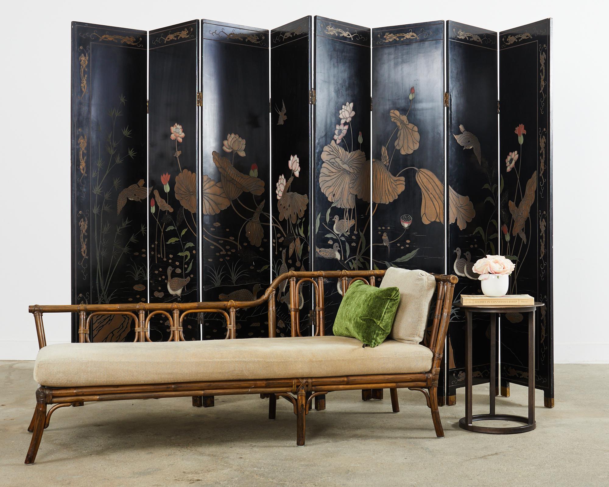 Grand Chinese export post republic period eight panel coromandel screen featuring a waterscape decorated with blossoming lotus and birds. The screen measures over 12 feet laid out flat with eight panels covered with lacquer, incised and painted with