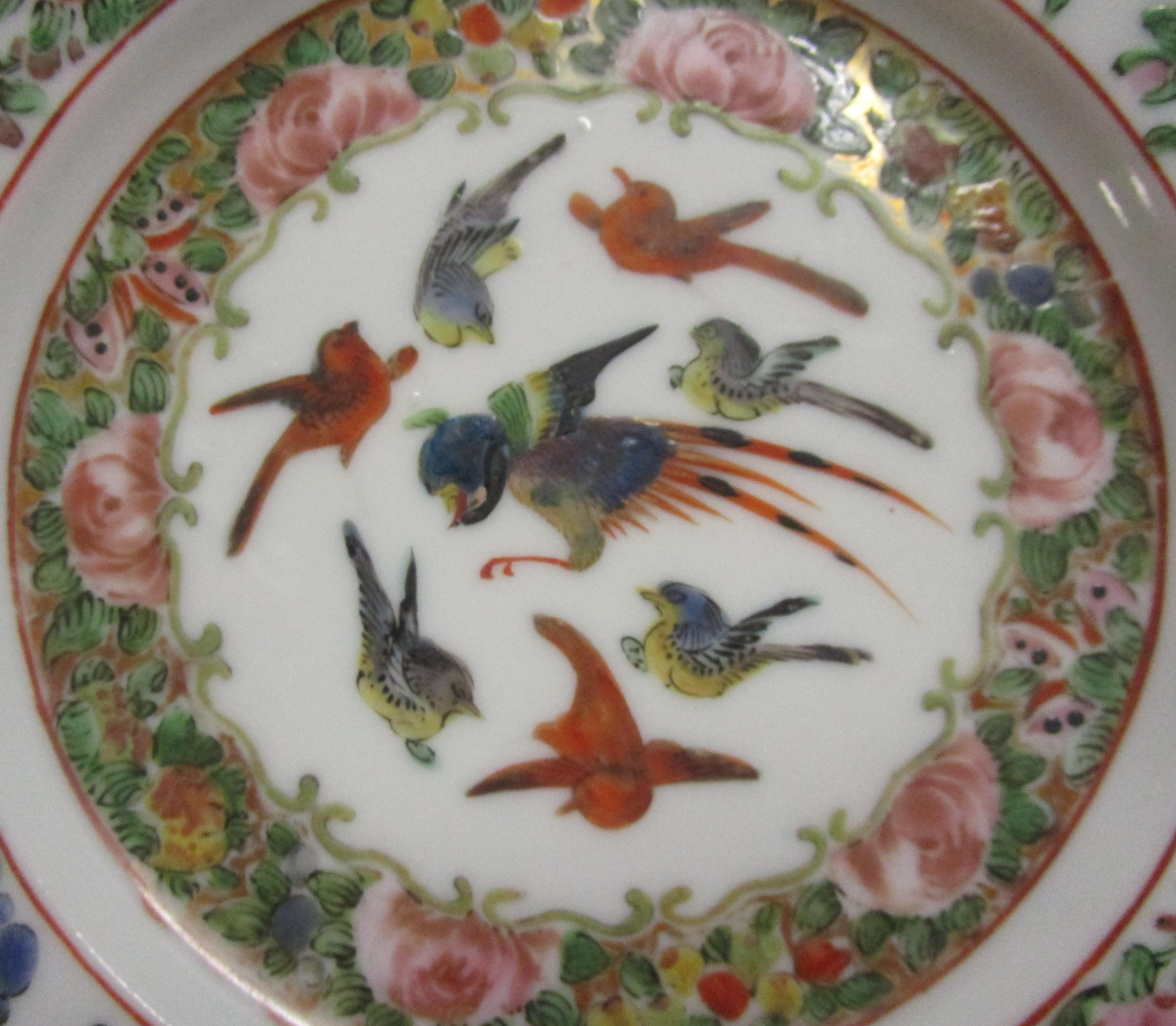 Chinese porcelain Famille Rose plate in a petite seven inch size. The enameled detail is incredible with various stylized colorful birds in the center and a rose and butterfly border with gold highlights.
 No markings on bottom. Perfect condition.