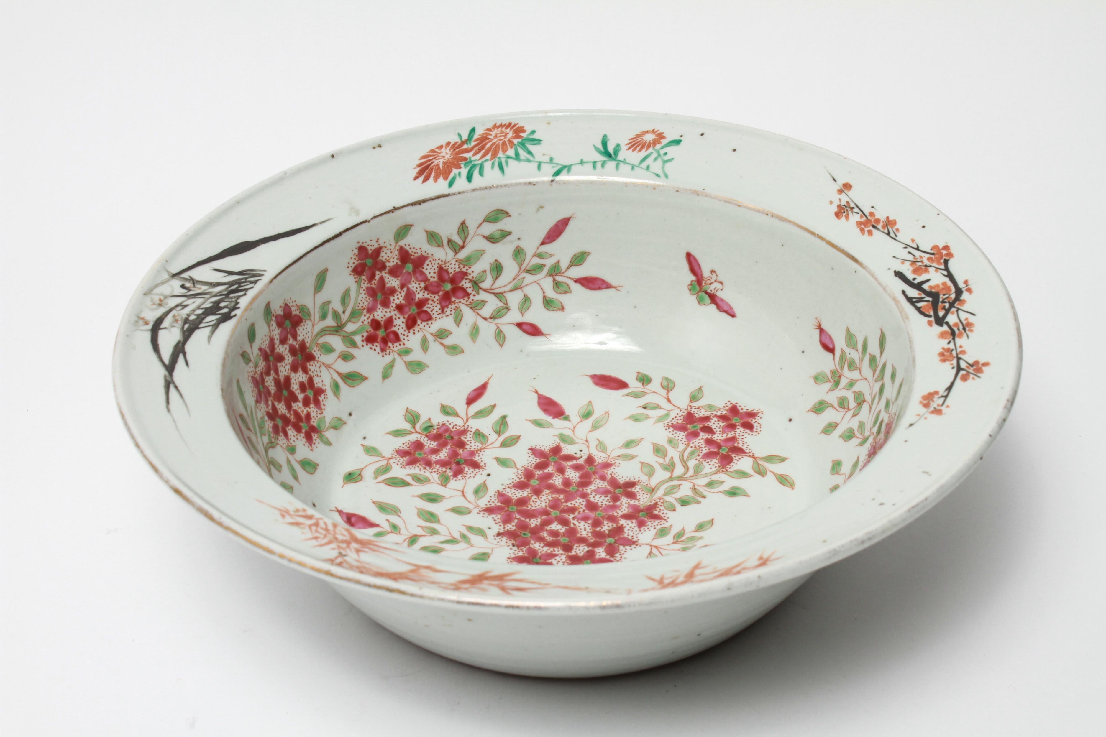 Chinese export Famille rose porcelain large bowl or basin. The piece has a polychrome floral motif and a gilt trim. In great vintage condition with age-appropriate wear and wear to the gilt trim.