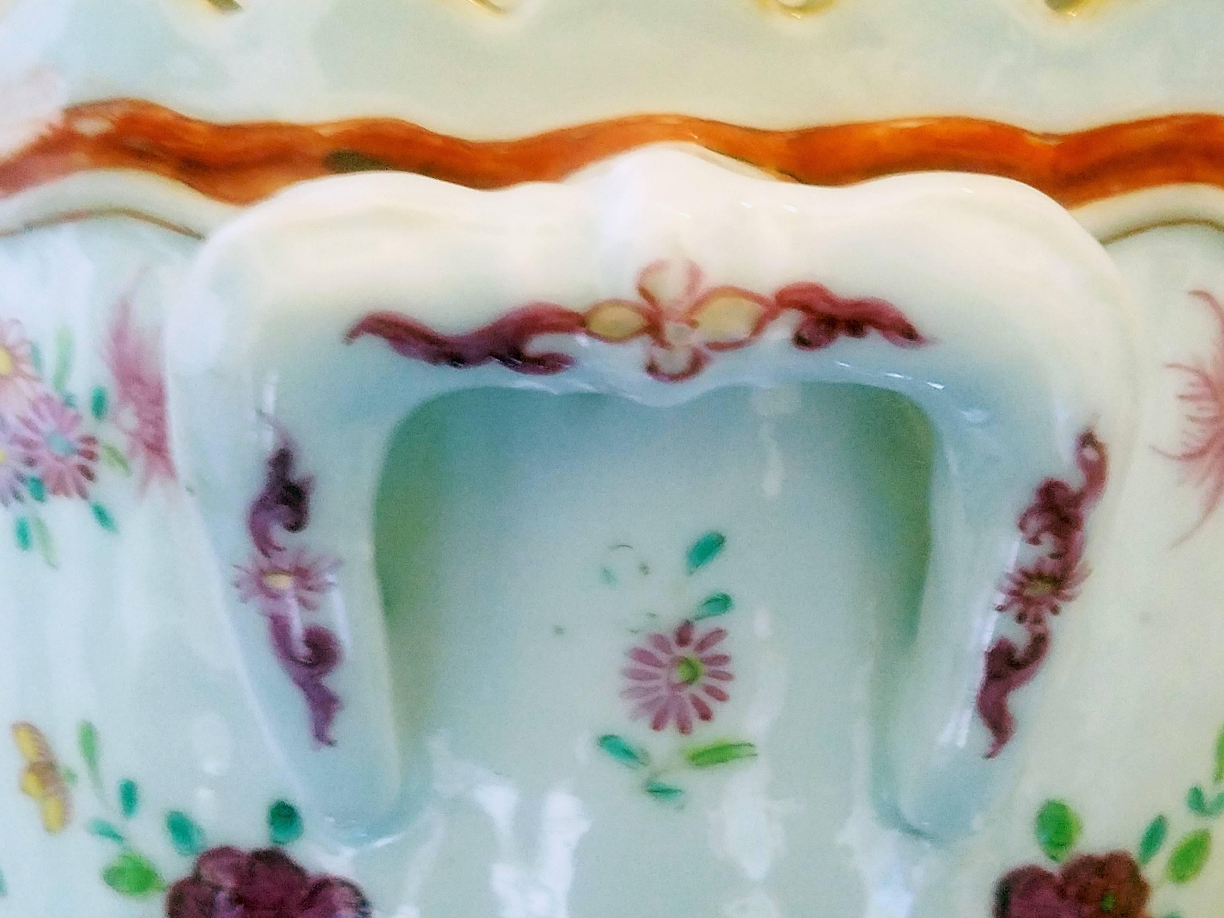 Chinese export famille rose porcelain wine cooler,
circa 1765.

The circular waisted cooler has an undulating rim edged in gold with a handle to the sides. The front and back decorated with a central painted arrangement in famille rose of loose