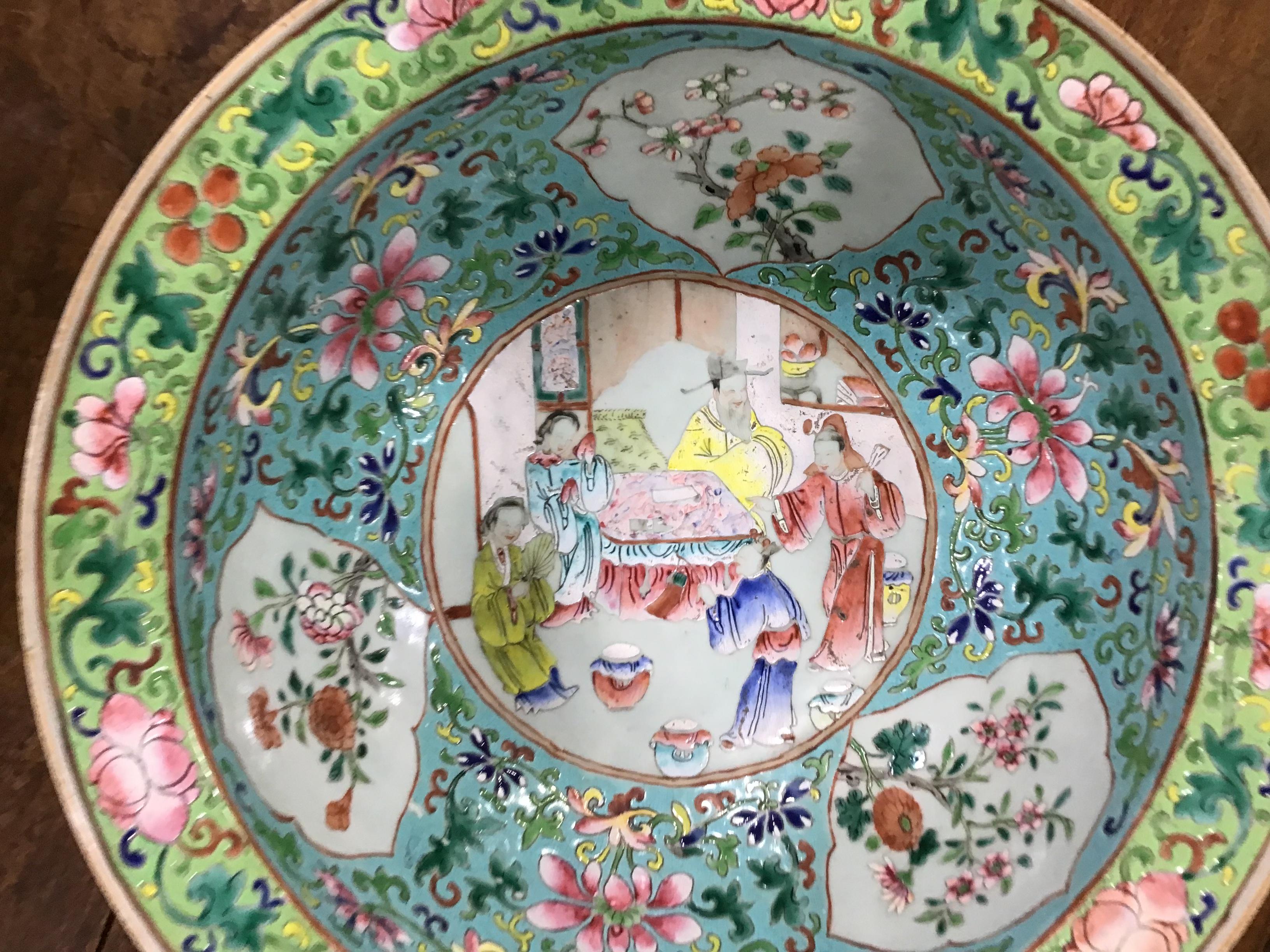 Chinese Export Famille Verte porcelain Bowl. Central interior court scene surrounded by panels with vibrant colored floral decoration. The exterior decorated with bamboo sprays. Early 19th century.