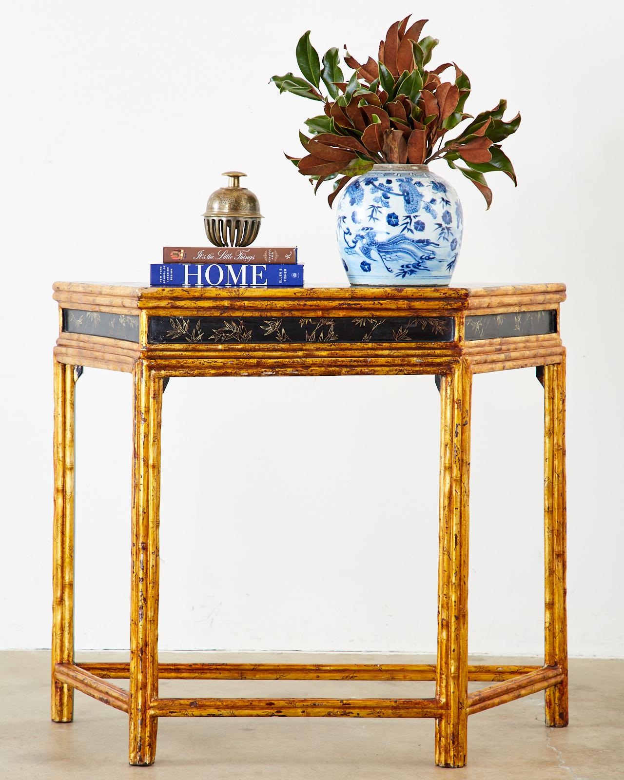 Extraordinary Chinese export console table featuring an angular demilune form of gilt decorated faux bamboo. The top is decorated with a Coromandel style black lacquered landscape scene. The frieze has an ebonized black lacquer inset with delicate