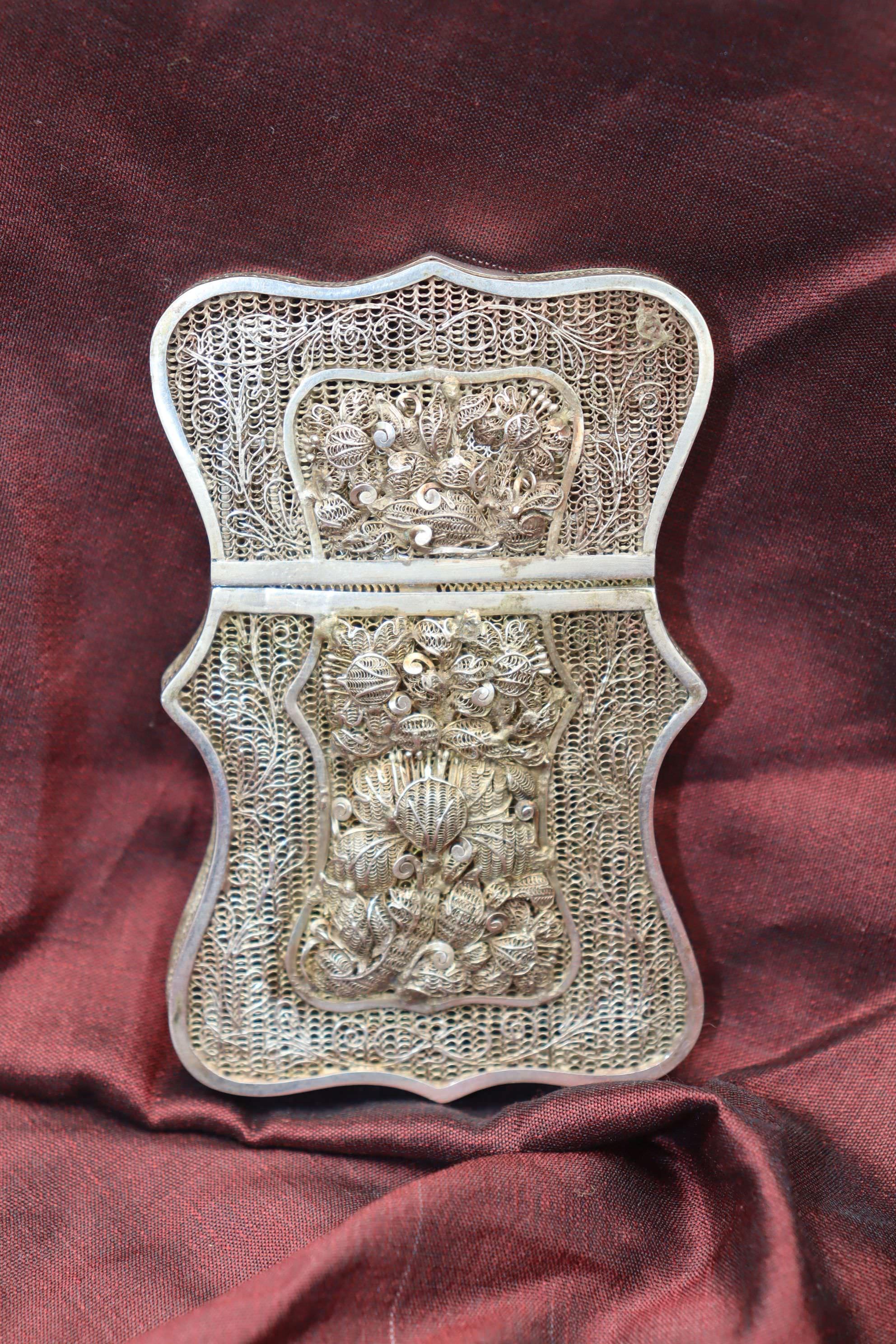 This Chinese filigree silver gilt card case with a lift off lid measures 88 mm (3.5 inches) in height, 56 mm (2.25 inches) in width and has a thickess of 16 mm (5/8ths of an inch). The central cartouches on either side feature intricate raised