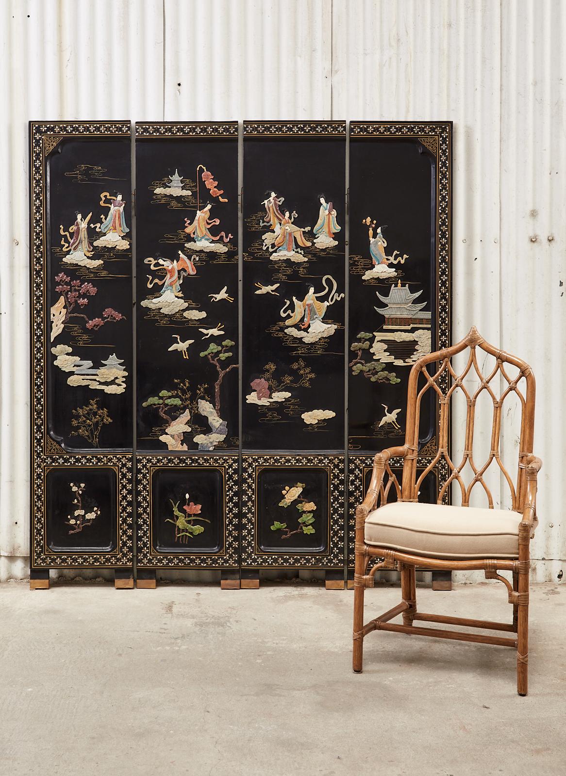 Impressive Chinese export four panel lacquered coromandel screen featuring hand-carved soapstone beauties in a floral landscape with gilt clouds. Each panel has recessed windows with floral motifs on each bottom panel. Supported by patinated brass