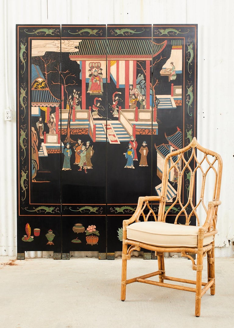 Colorful Chinese export four panel coromandel folding screen. The lacquered screen features incised panels depicting an Imperial royal pavilion with figures engaged in leisurely activities. The scene is bordered by green dragons and each panel has