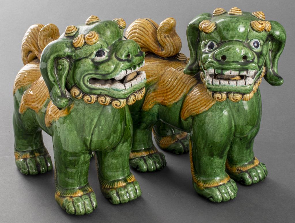 Pair of Chinese Export green and yellow glazed foo dogs / temple lion guardian figures, decorated in the Kangxi Qing dynasty taste with Sancai colors, modeled standing attentively. Measures: 10.25” H x 9.5” W x 4.5” D.