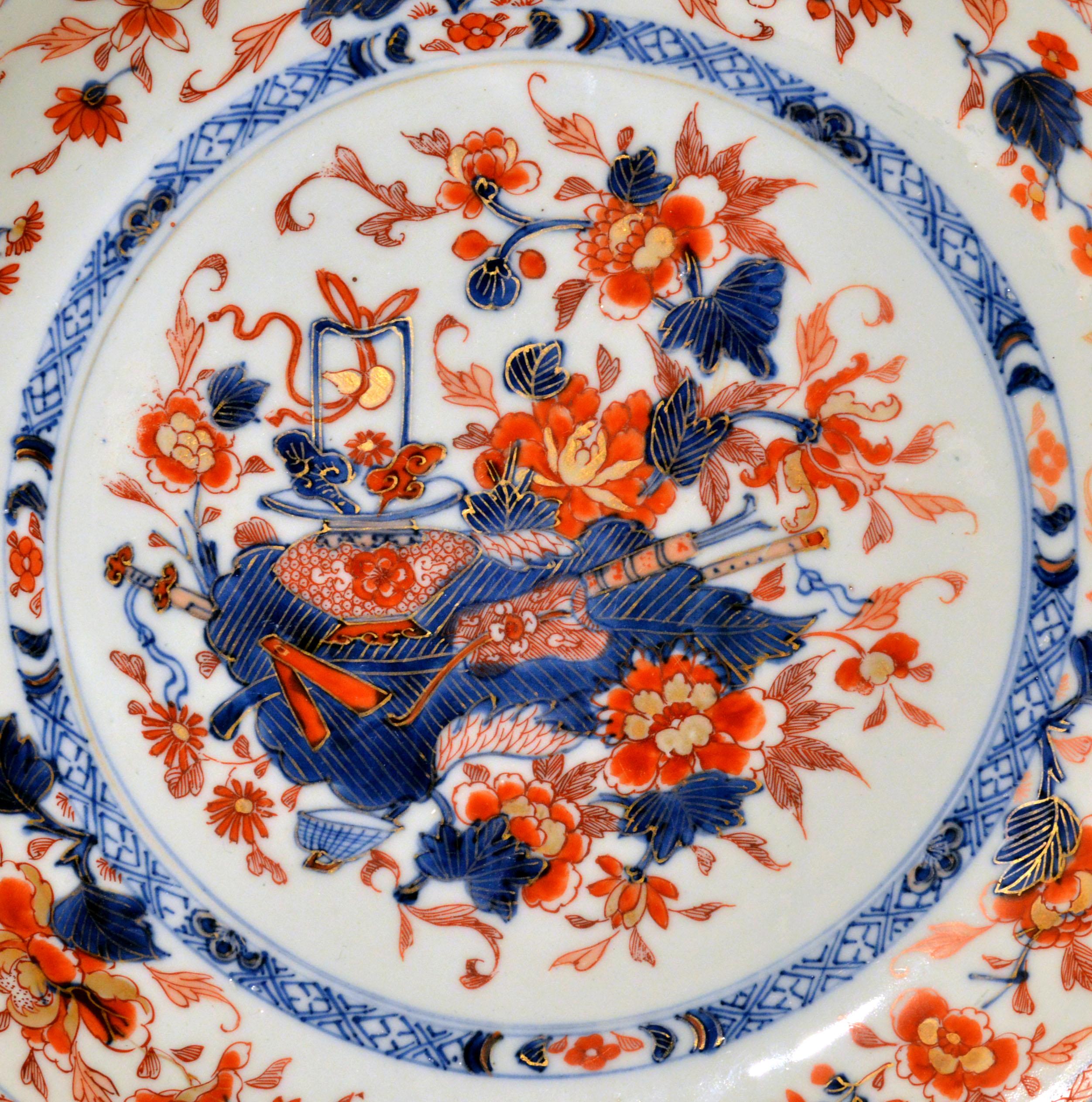 Chinese Export Imari large porcelain saucer dish 
circa 1770


The Chinese Export Imari Porcelain saucer dish is painted in the central well with a group of precious objects on an acanthus leaf surrounded by flowering plants enclosed by an