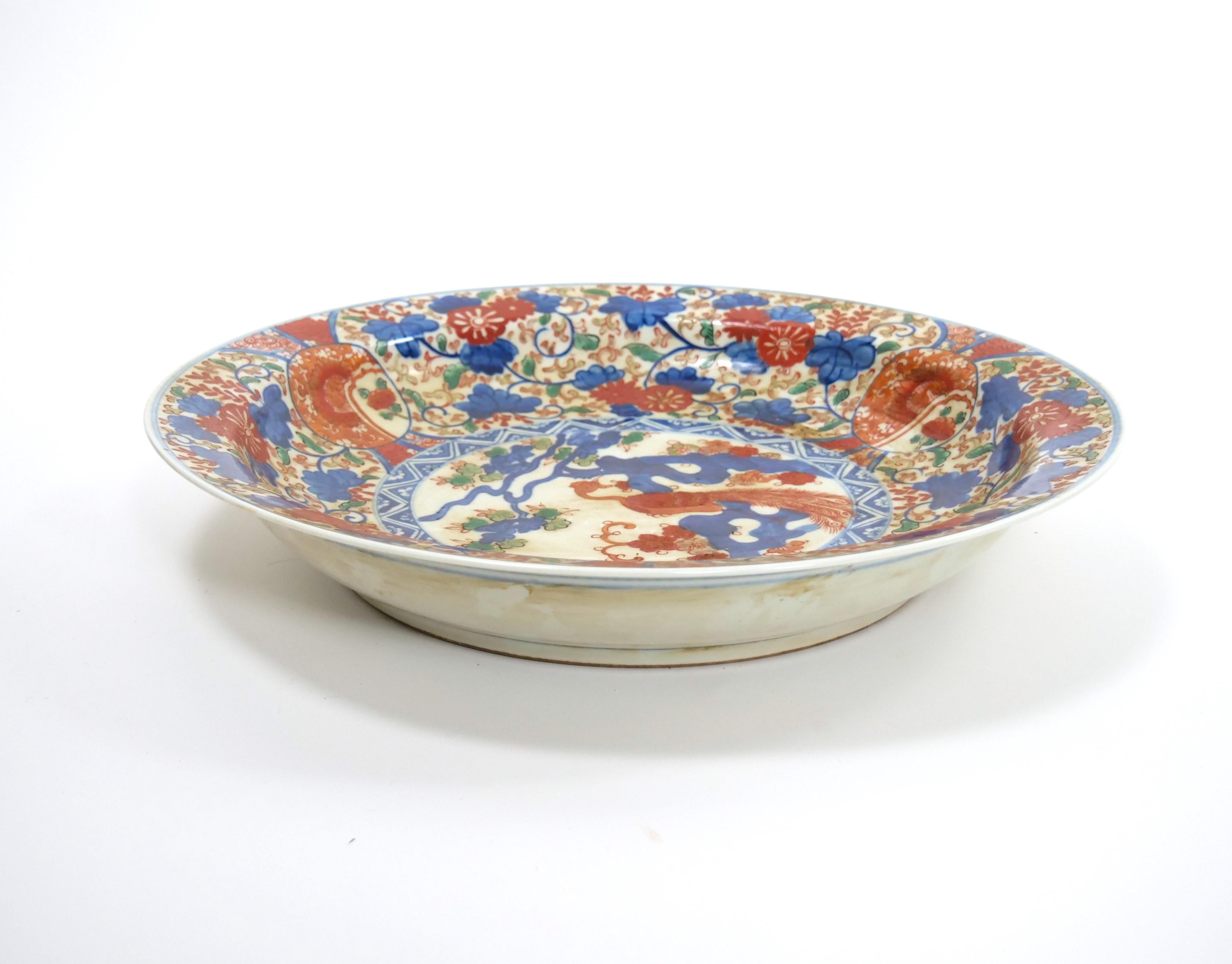 Add a touch of elegance to your space with this exquisite Chinese Export Imari Porcelain Phoenix Design Decorative Plate. The plate showcases a stunning phoenix design, beautifully painted with intricate details and vibrant colors, making it a