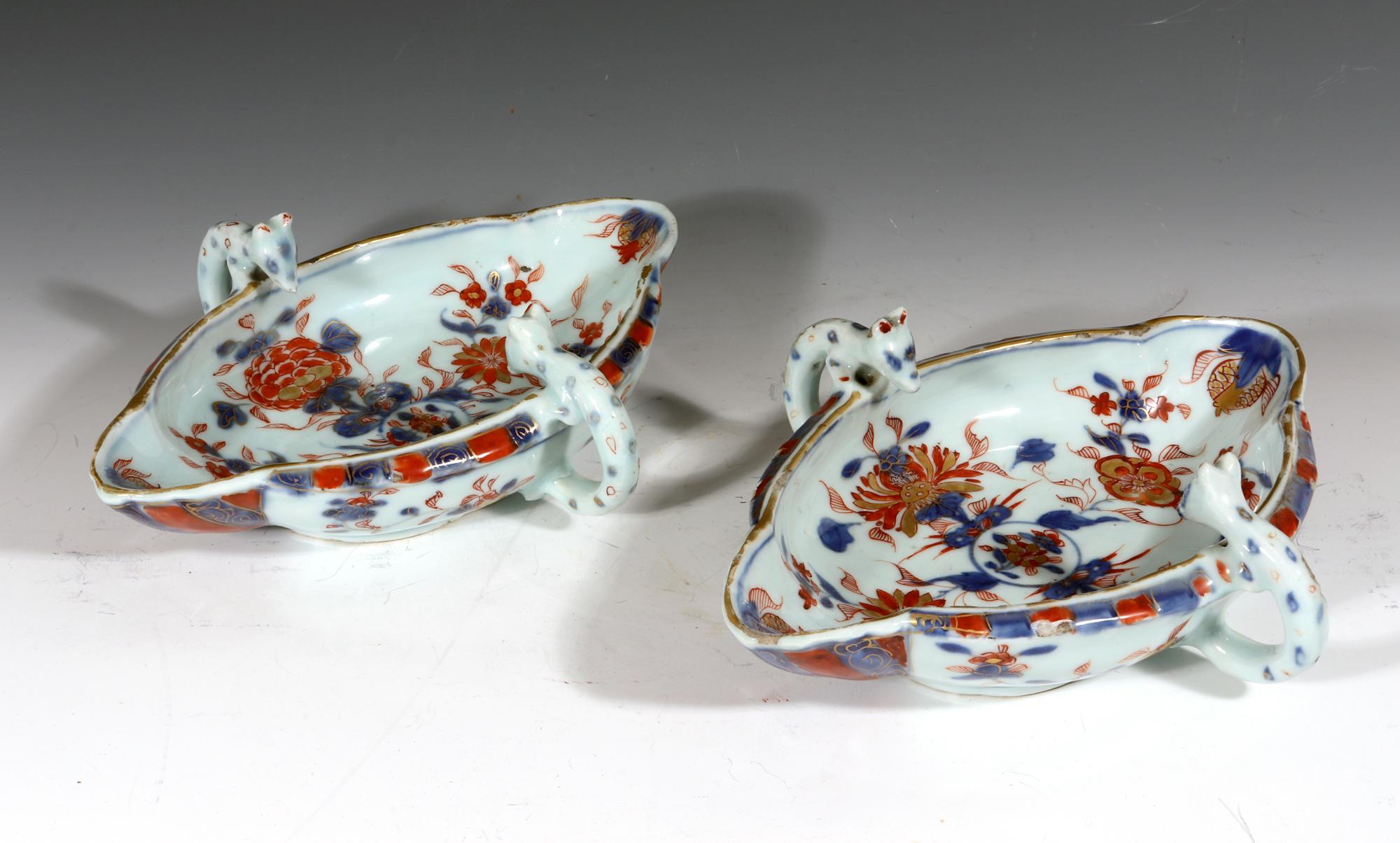 Chinese Export Kangxi period imari sauce boats.
Circa 1700.

The pair of Chinese Export Imari-colored sauce boats have a shaped oval form with handles formed by stylized animals with the heads protruding above the rim peaking into the boat. They