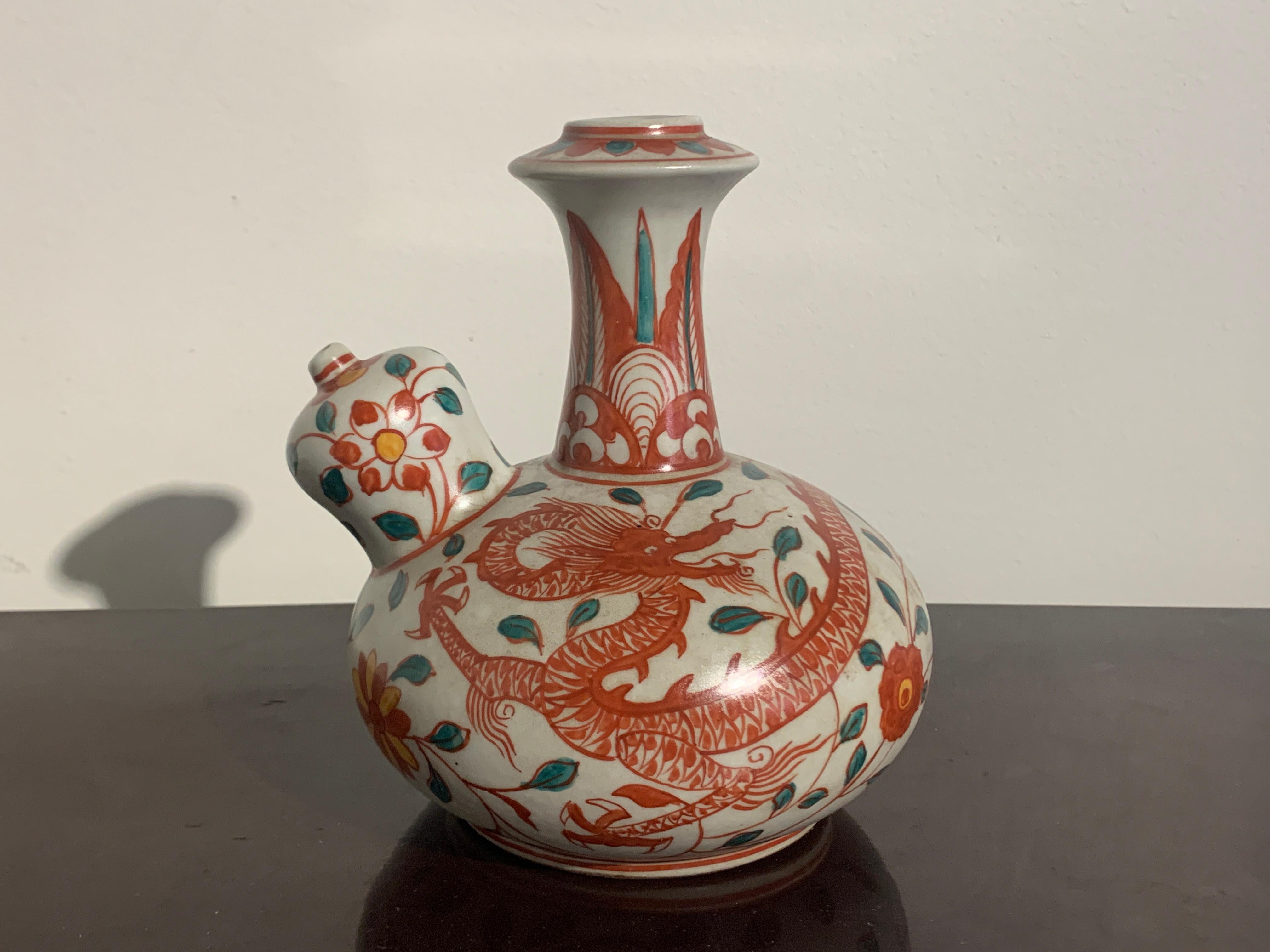 A delightful Swatow ware Chinese export shipwreck porcelain kendi featuring a writing dragon and an apocryphal Tongzhi mark, late 19th or early 20th century, China, made for the Indonesian market. 

The kendi is decorated in wonderful and