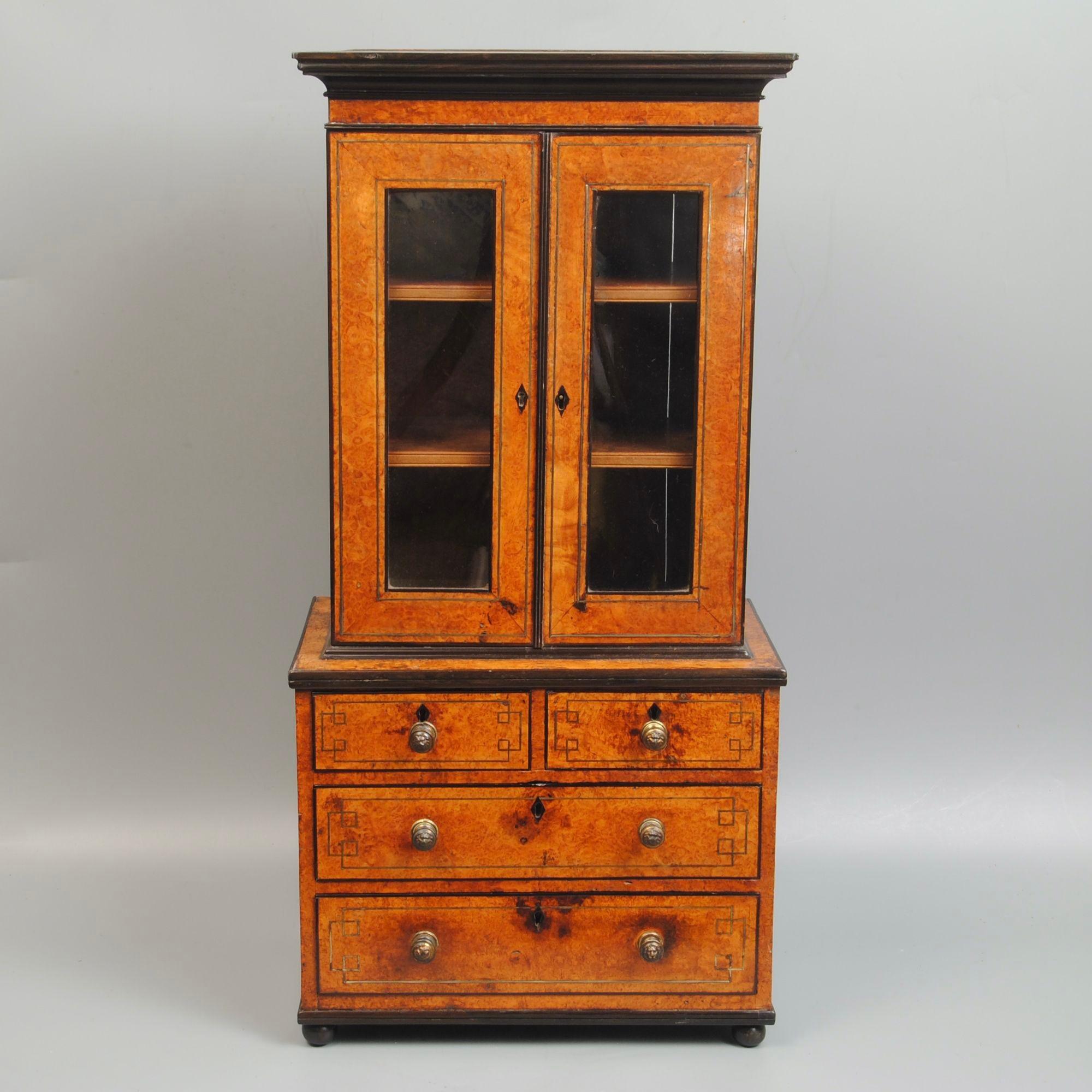 Un'affascinante libreria in miniatura a due ante in amboyna con raffinati intarsi in ottone e modanature in ebano, cinese, circa 1825
Buon colore e patina.