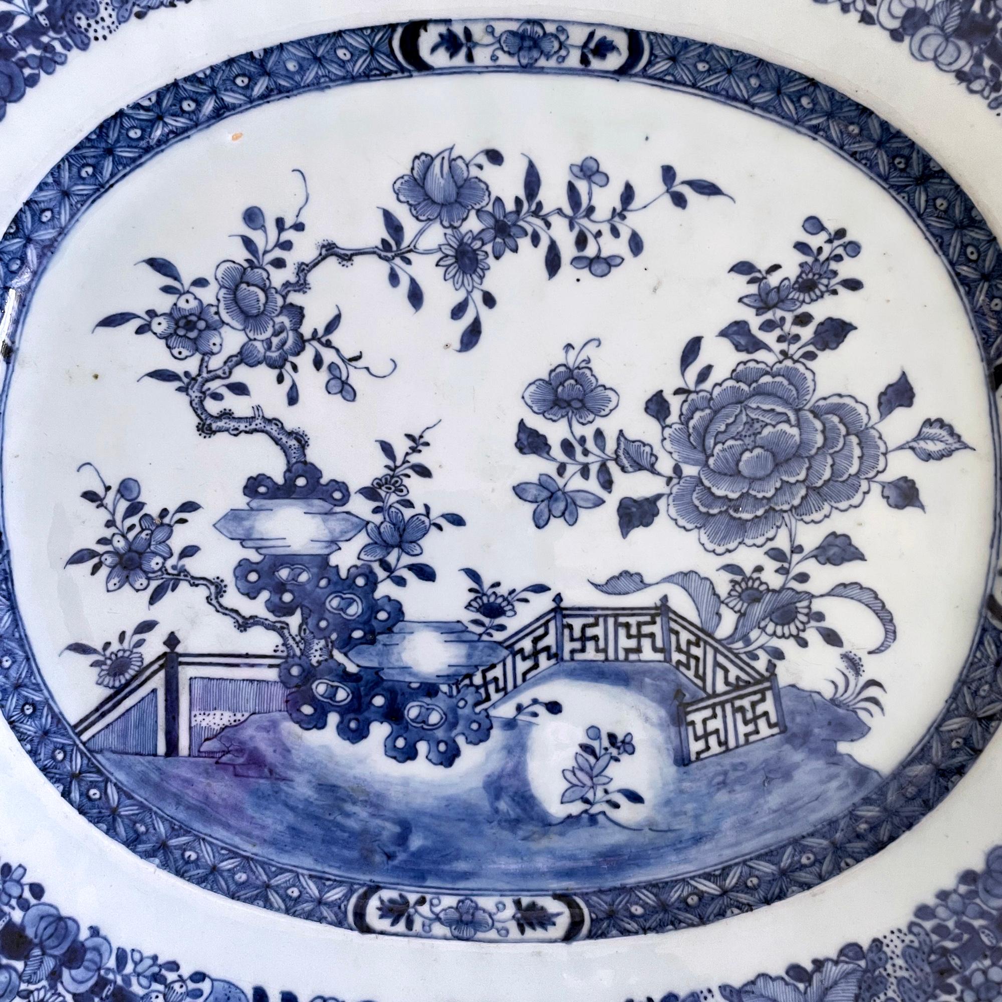 Chinese Export Porcelain blue & white massive dish,
Circa 1770 

The massive underglaze blue and white Chinese Export dish is painted with a garden scene with flowering plants growing in the ground and on rockwork. The scene is centered with a