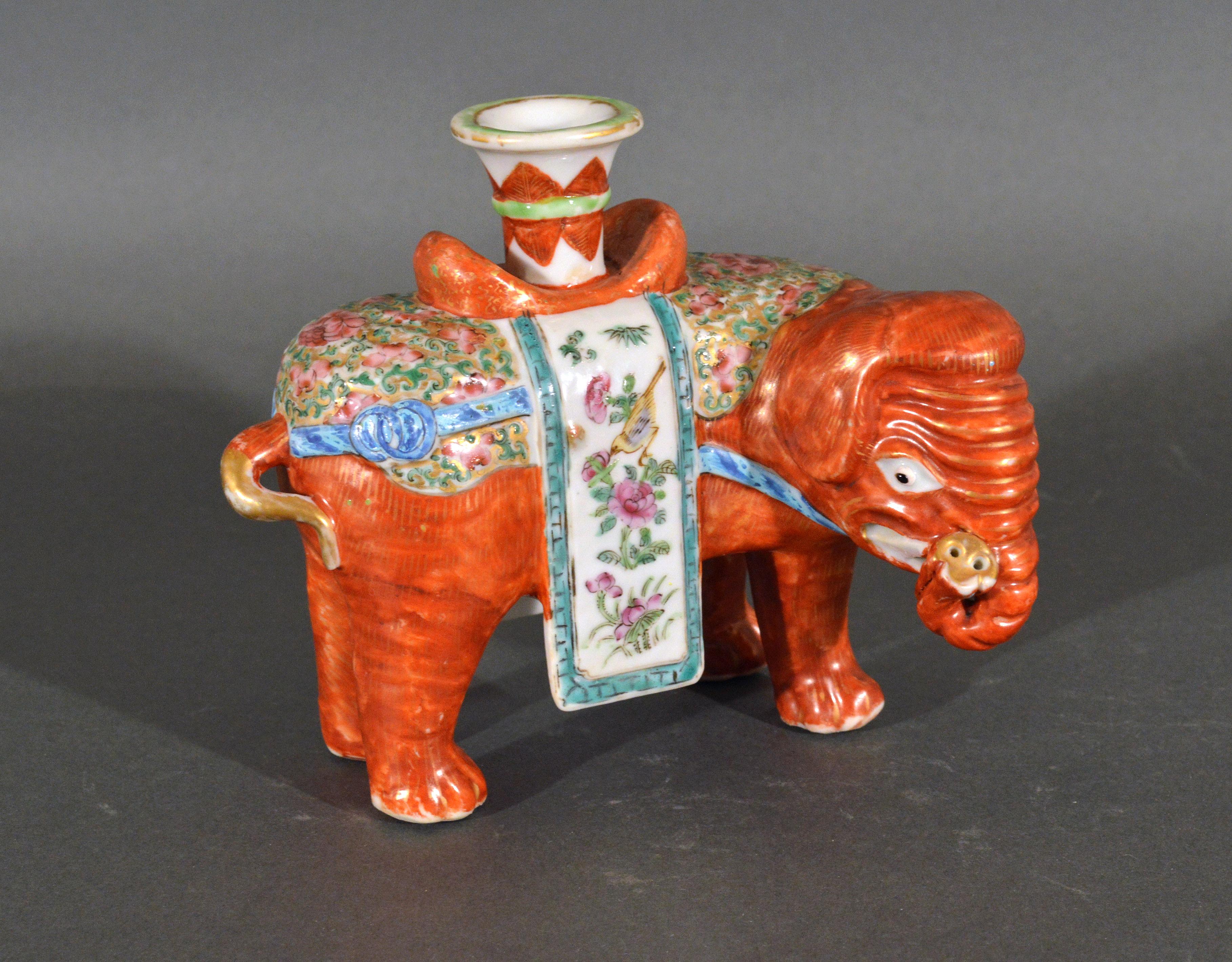 Chinese Export porcelain canton famille rose elephant modeled as a candlestick,
circa 1860 

The standing Chinese Export porcelain elephant with its trunk up is painted in an iron-red with gilt decoration and caparisoned. On its back is a gu-form