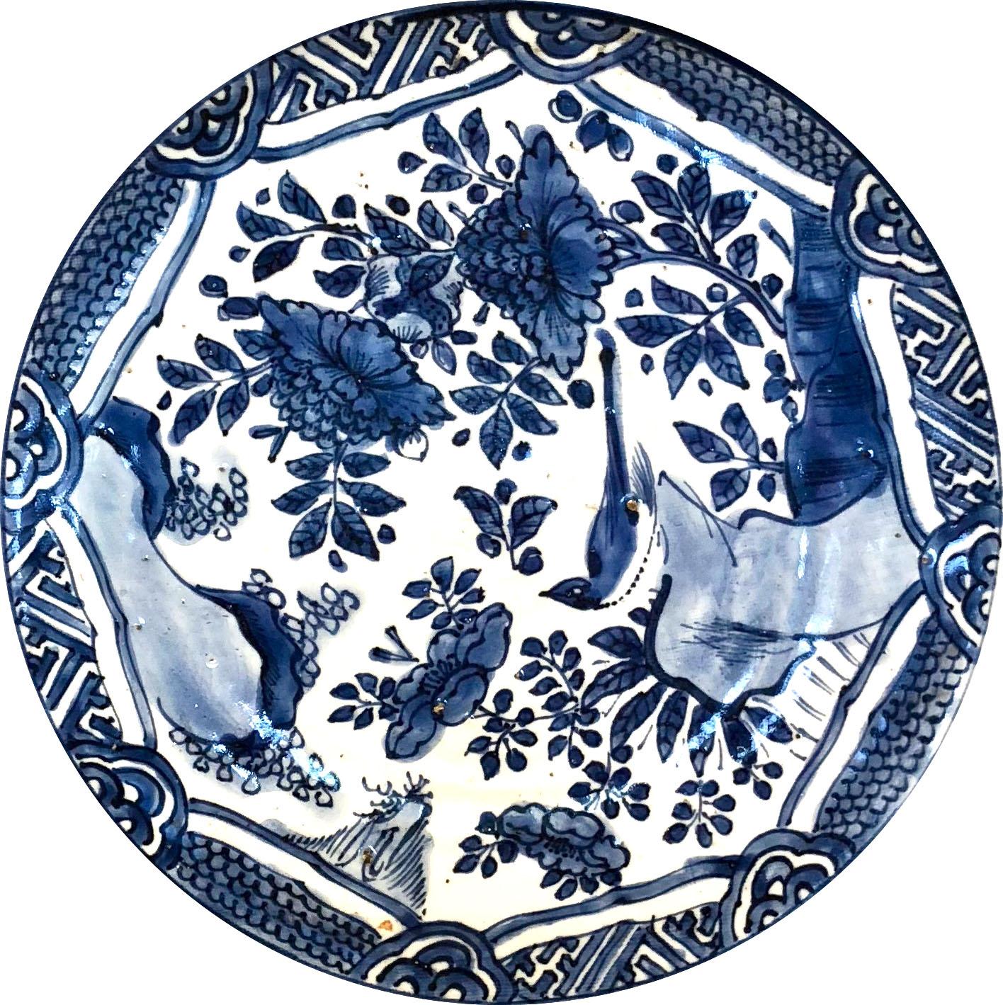 A Chinese porcelain dish, so-called kraakporselein, Ming Dynasty, Wanli Period (1573-1619), Jingdezhen kilns. Underglaze blue decoration depicting a lobed medallion with a landscape and a bird landed on a rock. The medallion is framed by a band of