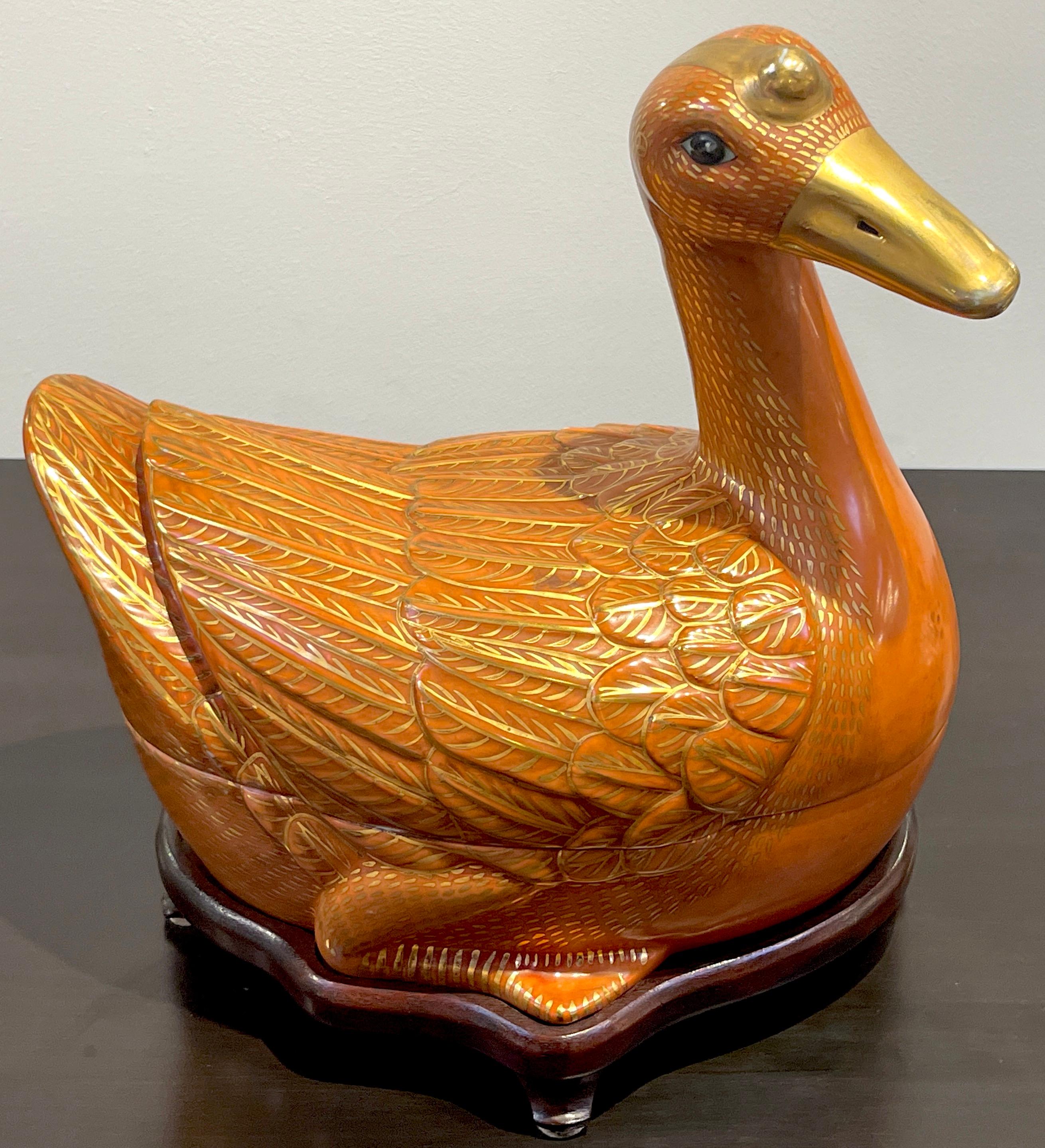 Chinese Export Porcelain figural iron red and gilt duck tureen & stand 
Later 20th century 
Of large size, realistically modeled and painted, the tureen in two parts, complete with a carved hard wood fitted stand.
The bottom bears a apocryphal