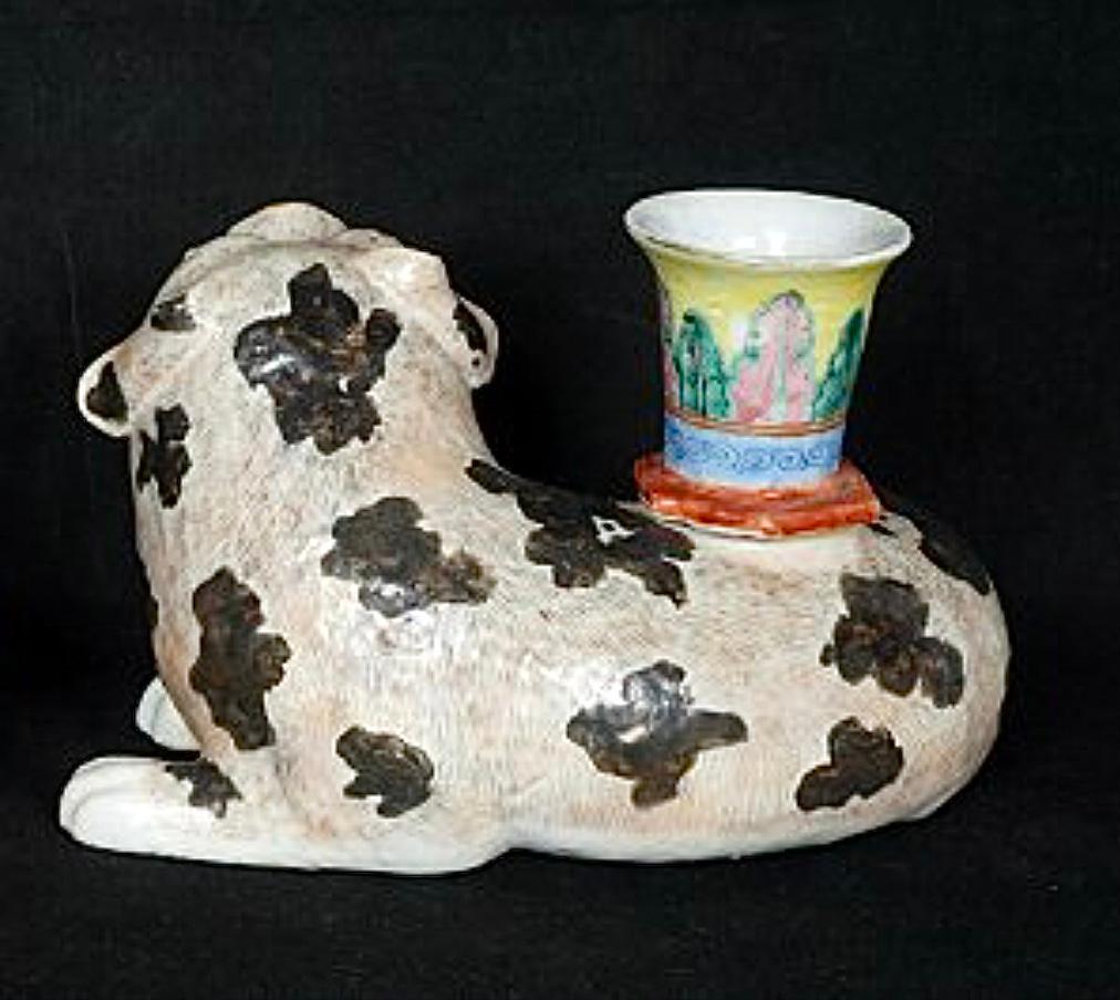 Chinese Export porcelain foo dog candlestick, modeled with the dog seated on all fours with paws showing. The open mouth dog with expression on their face, enameled with a neutral ground with decoration looking like fur. There is a short candlestick